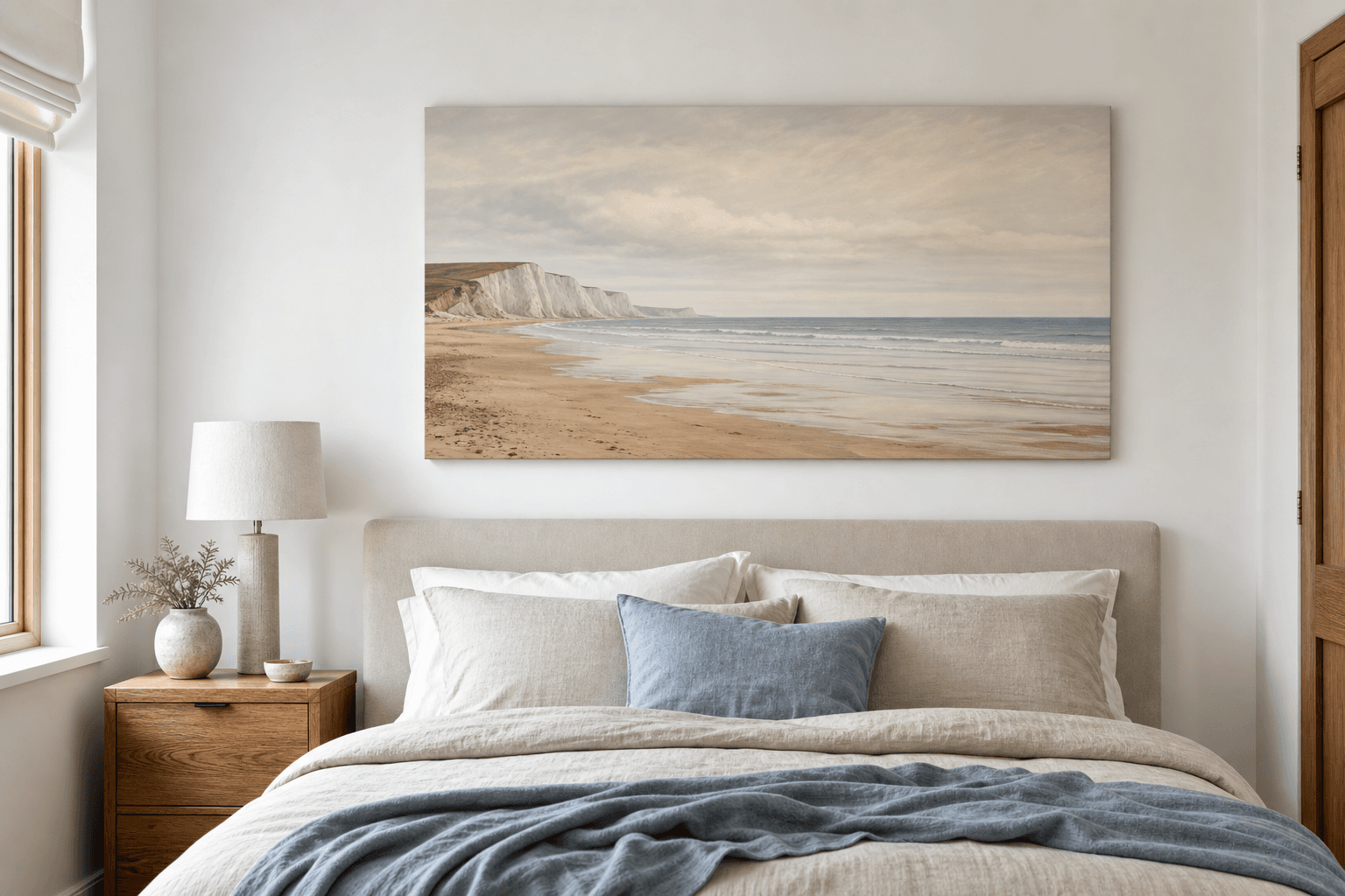 Grown-up bedroom with a muted beach canvas above a linen headboard.