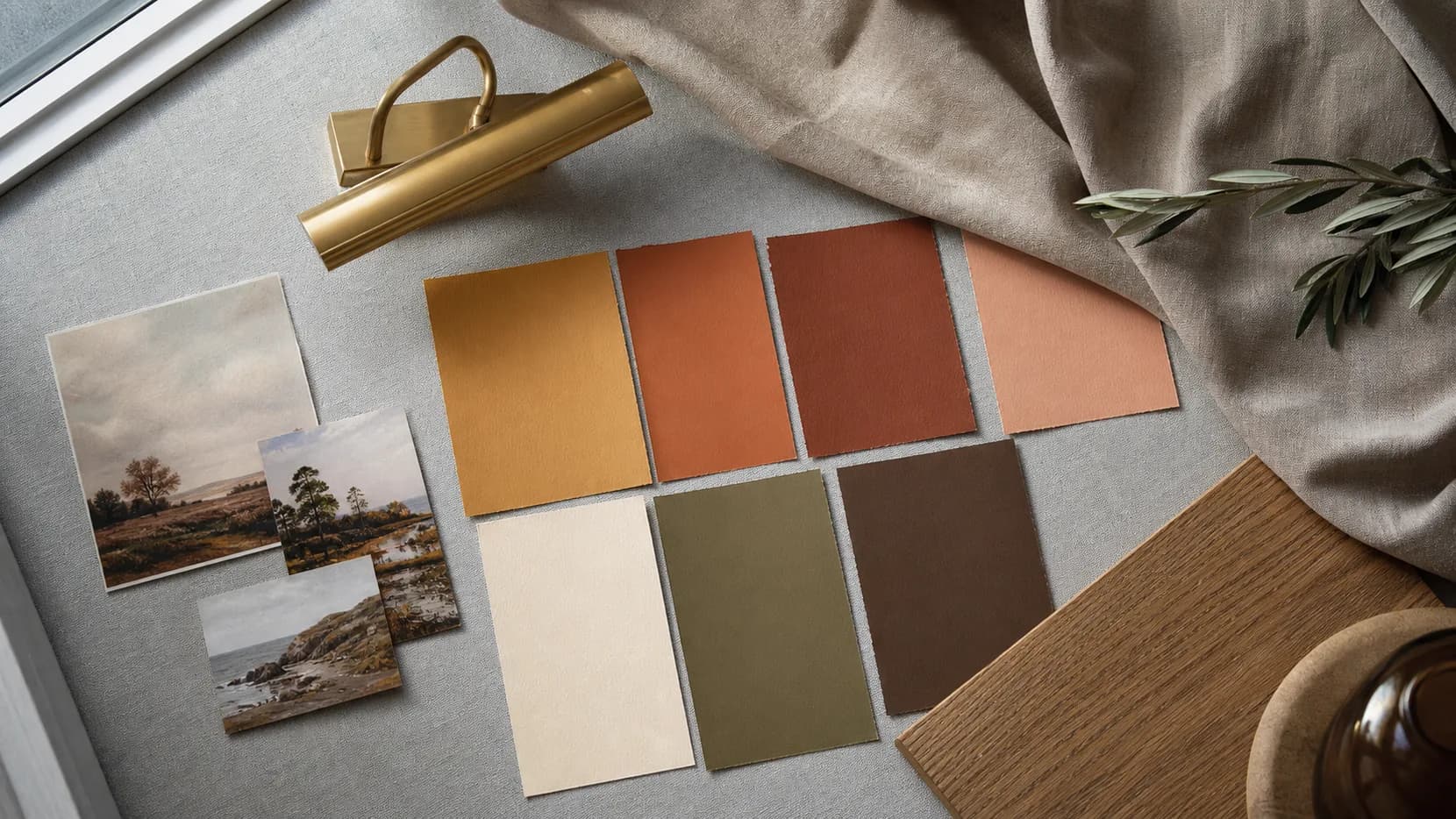 Warm colour swatches, landscape thumbnails, brass lighting and linen for a north-facing room.