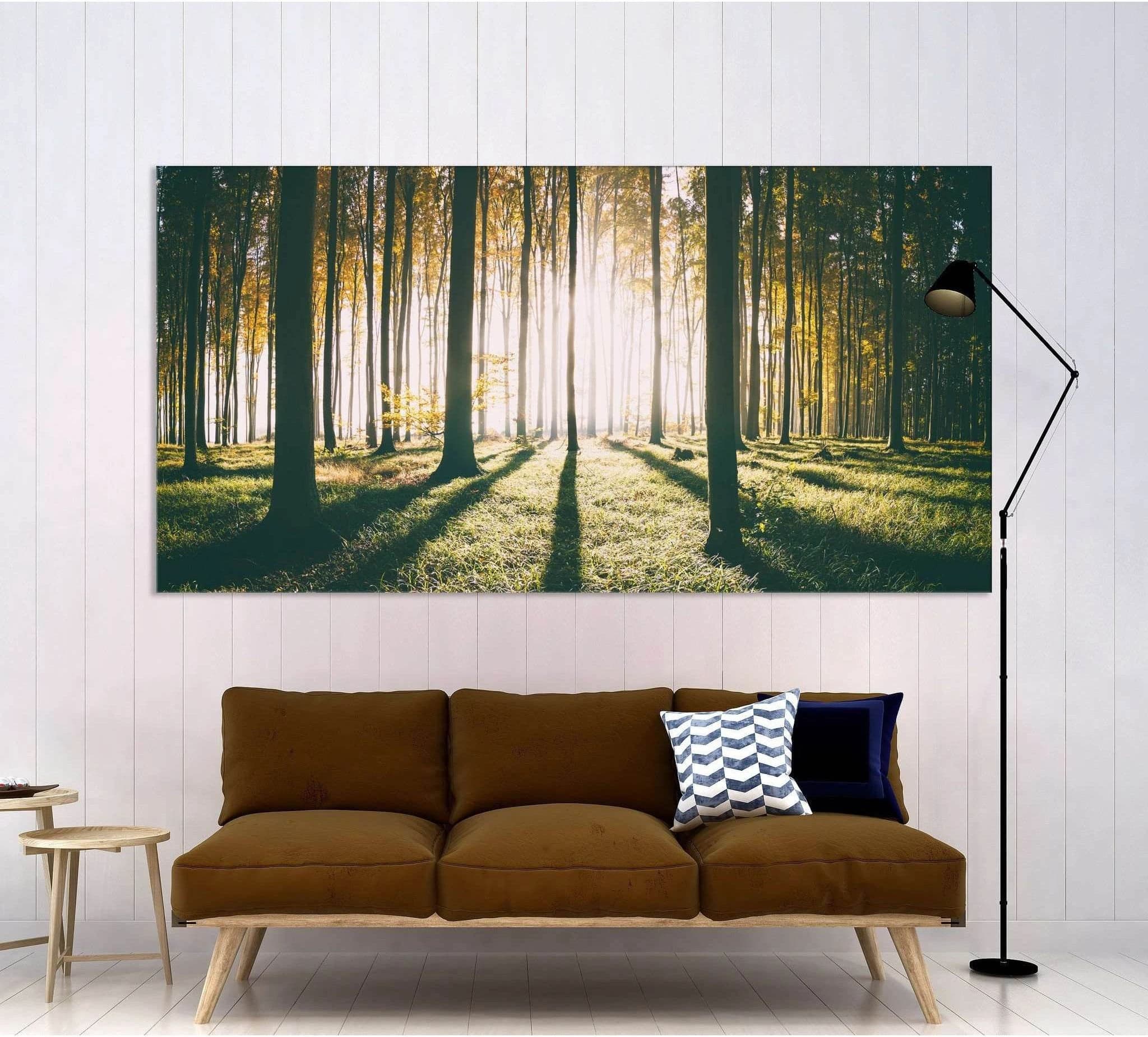 Sunlit autumn forest with tall tree trunks, mist, and golden sunbeams detail view