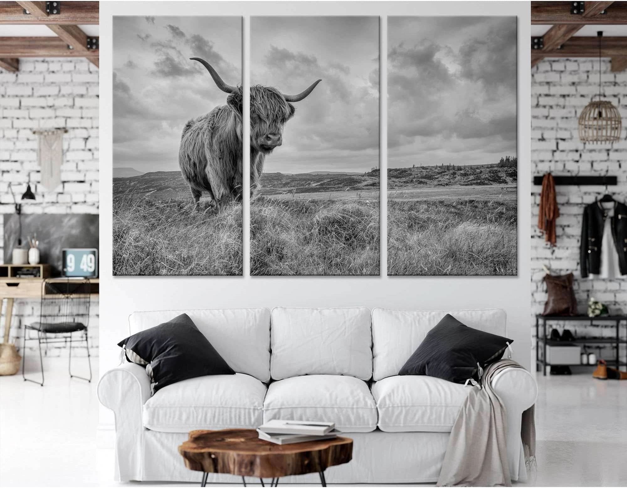 A black and white photograph of a Highland cow in a field of tall grass, with a dramatic sky and mountains in the background., product view 2