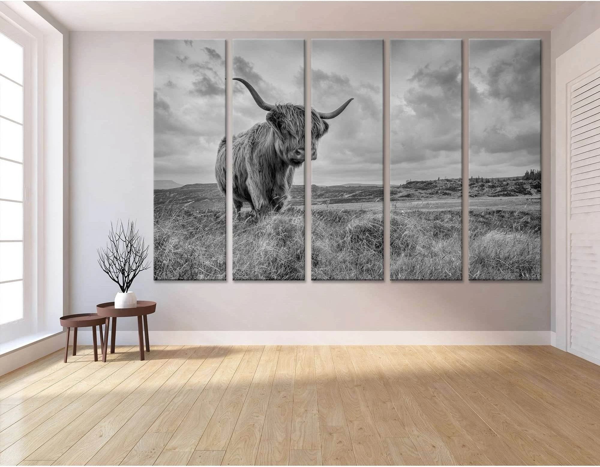 A black and white photograph of a Highland cow in a field of tall grass, with a dramatic sky and mountains in the background., product view 3