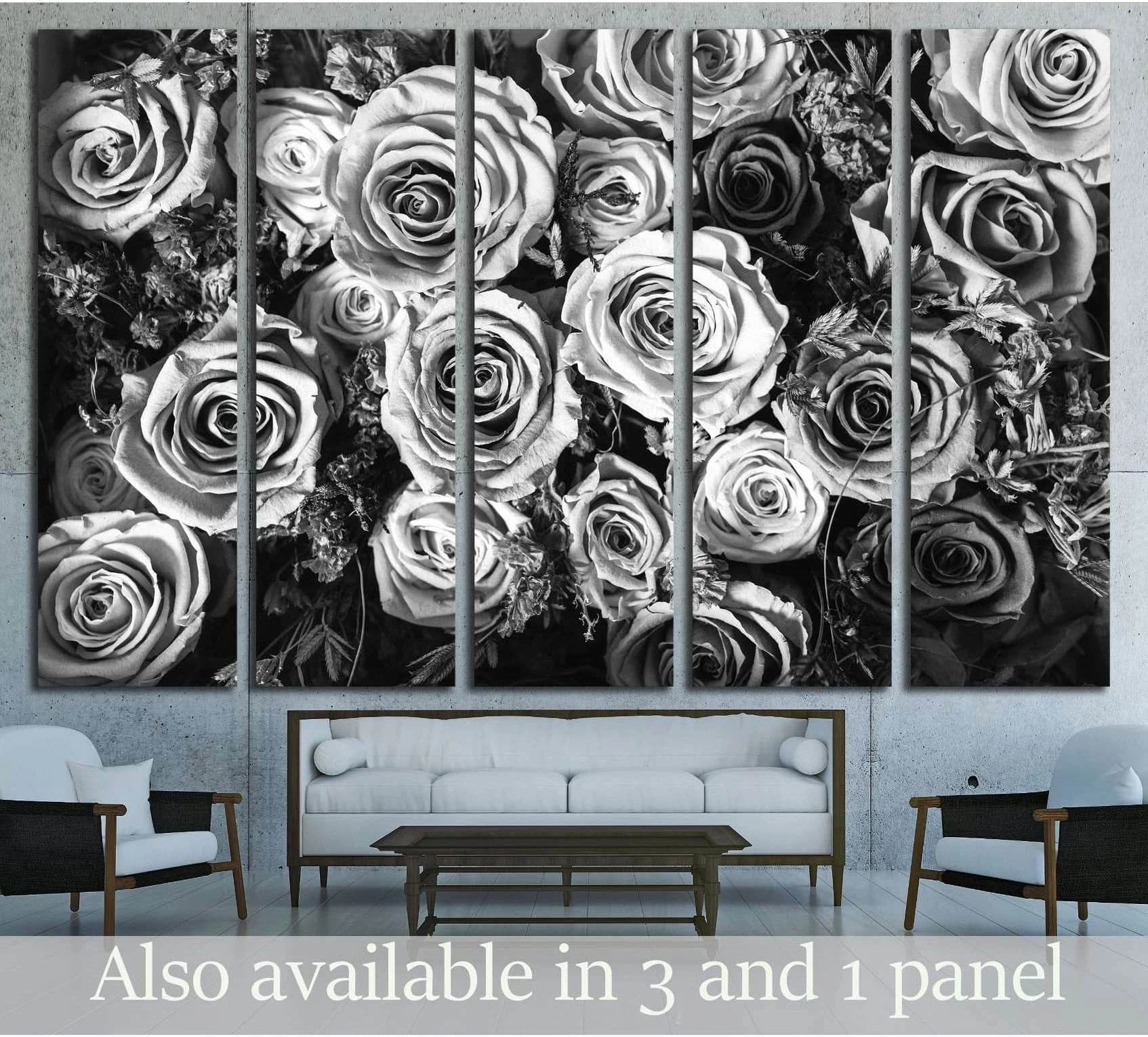 Black and white roses canvas print in a five-panel floral arrangement above a sofa in a modern living room