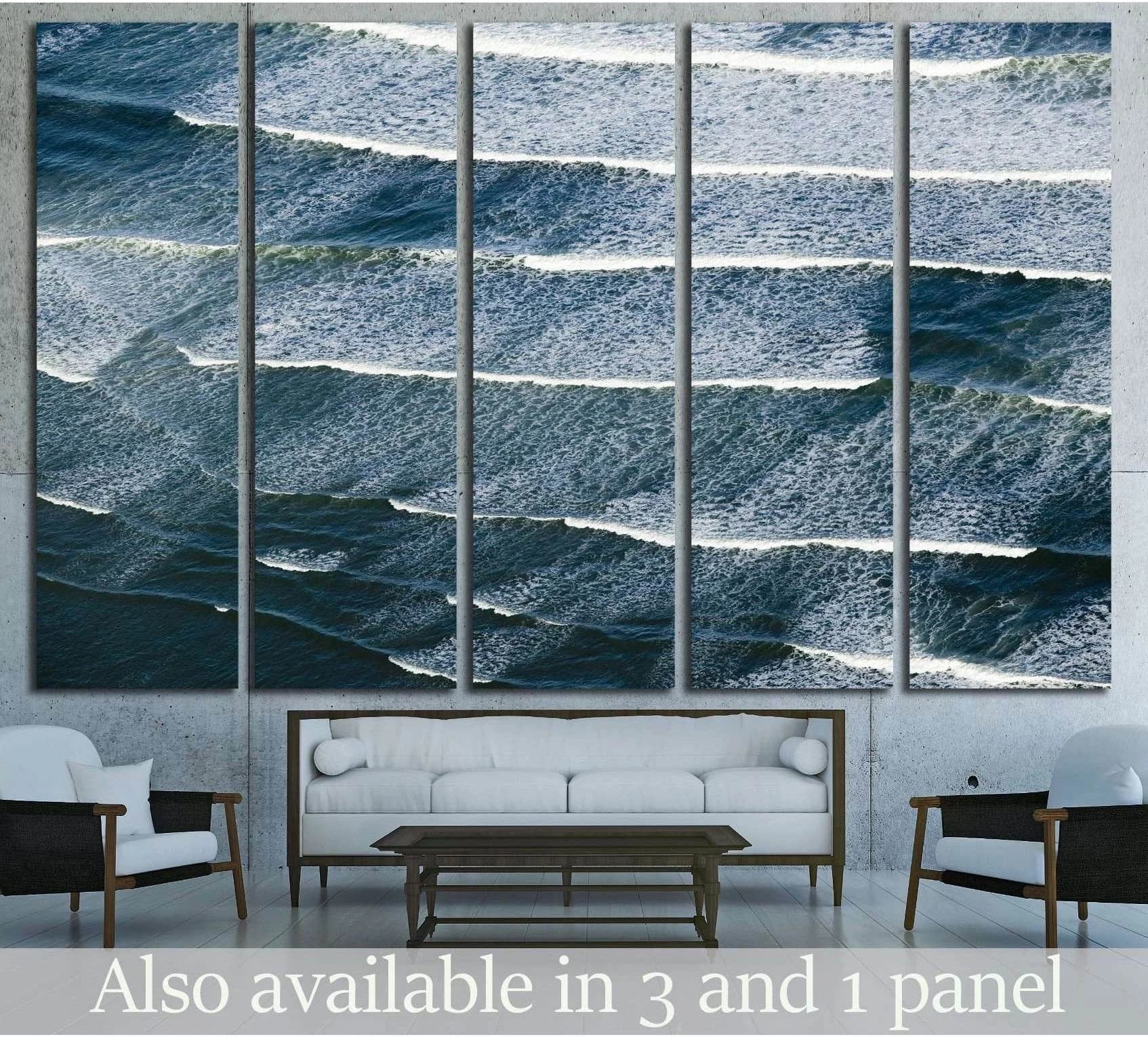 Aerial ocean waves canvas print hung above a sofa in a modern coastal living room