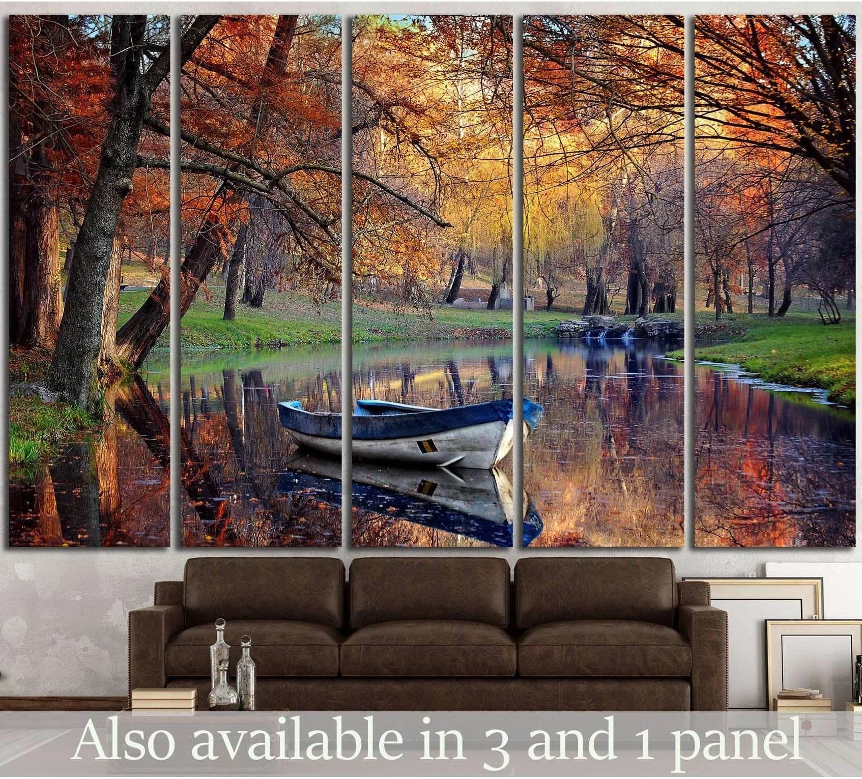 Autumn lake rowboat canvas print above sofa with fall trees and water reflections