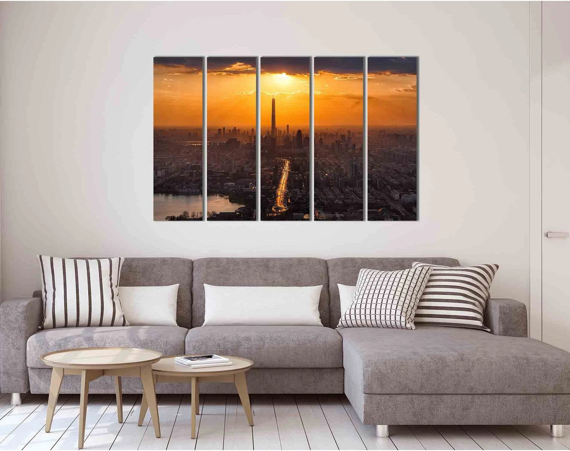 Sunset city skyline with a tall tower, glowing golden sun, and river reflections at dusk detail view