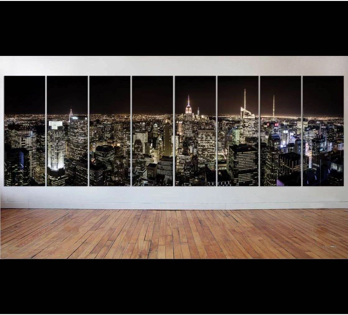 8-panel New York skyline canvas print with glowing Manhattan towers at night in a modern room