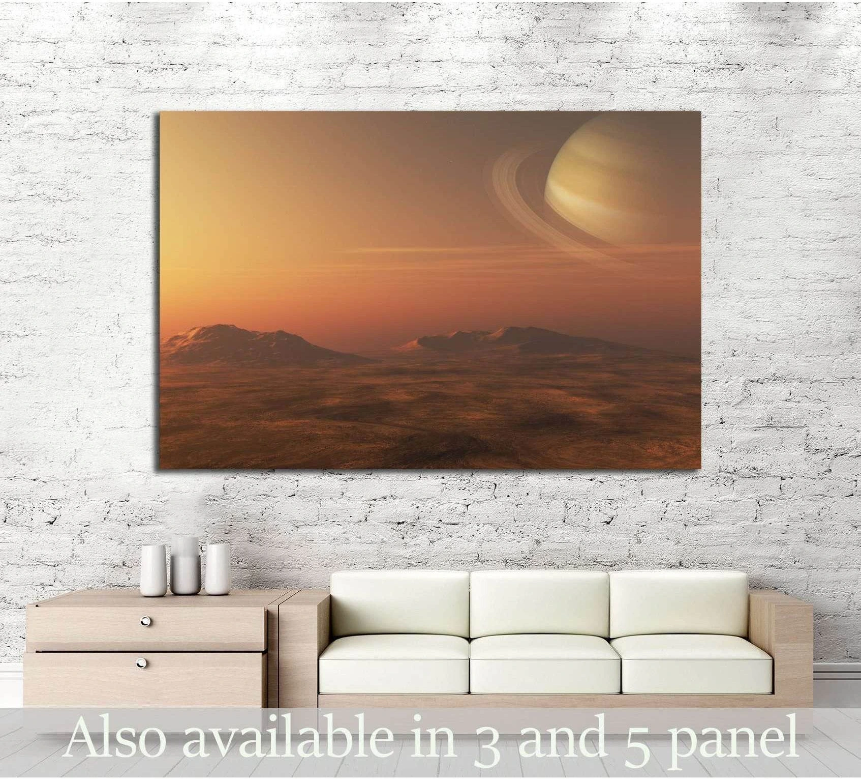 Saturn canvas print with ringed planet over an orange alien landscape, hung above a sofa in a modern living room