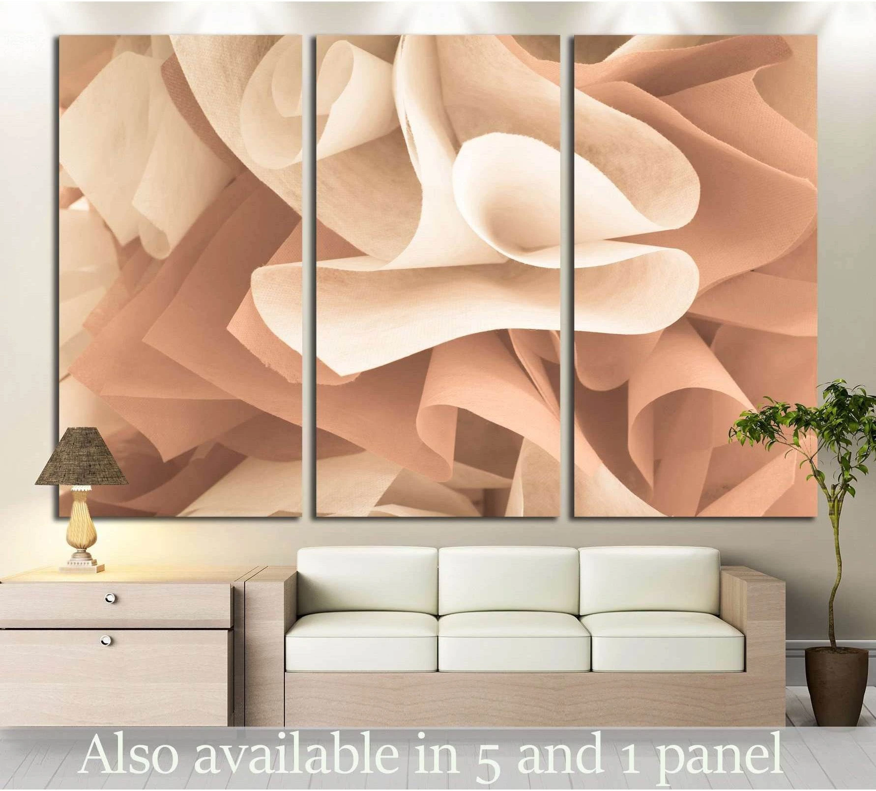 Rose gold abstract triptych canvas print with blush peach folded forms above a sofa