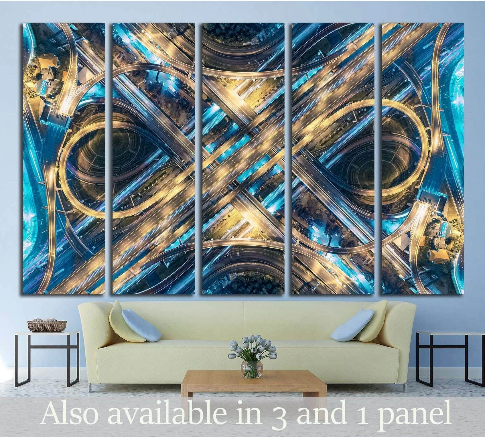 Aerial highway intersection canvas print in blue and gold tones above a sofa in a modern living room