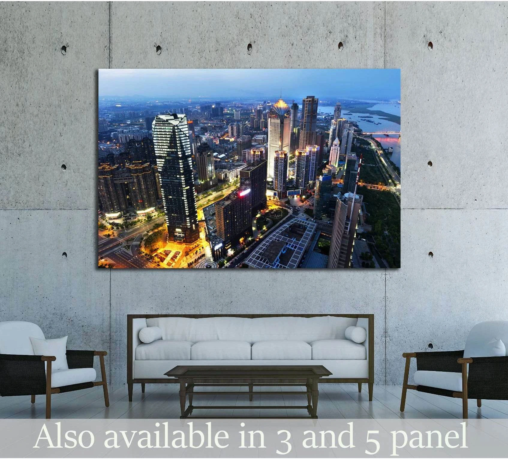 Aerial city skyline canvas print hung above a white sofa in a modern concrete living room