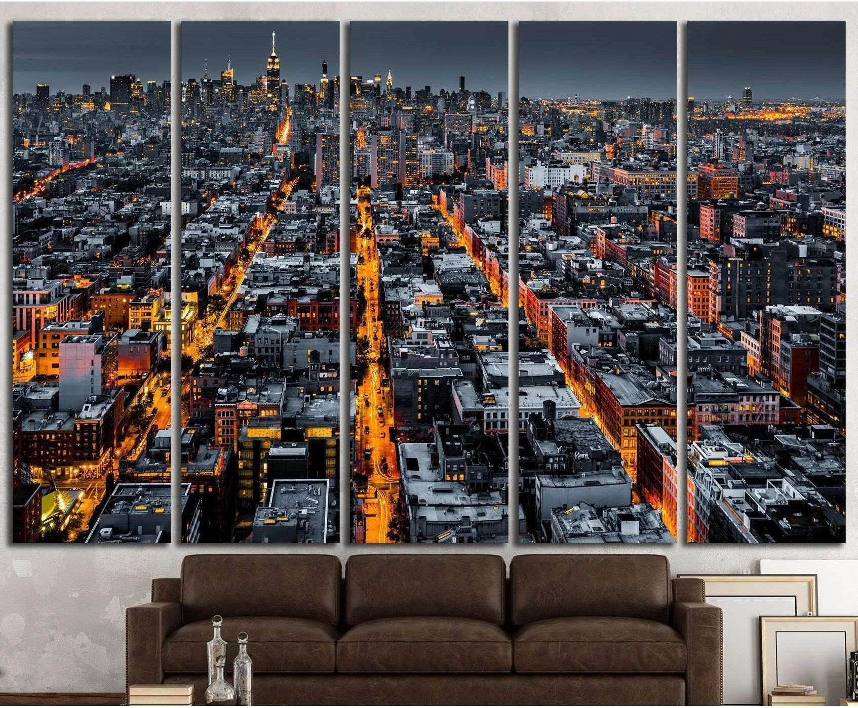 Aerial NYC skyline canvas print with glowing streets and Manhattan towers above a brown sofa