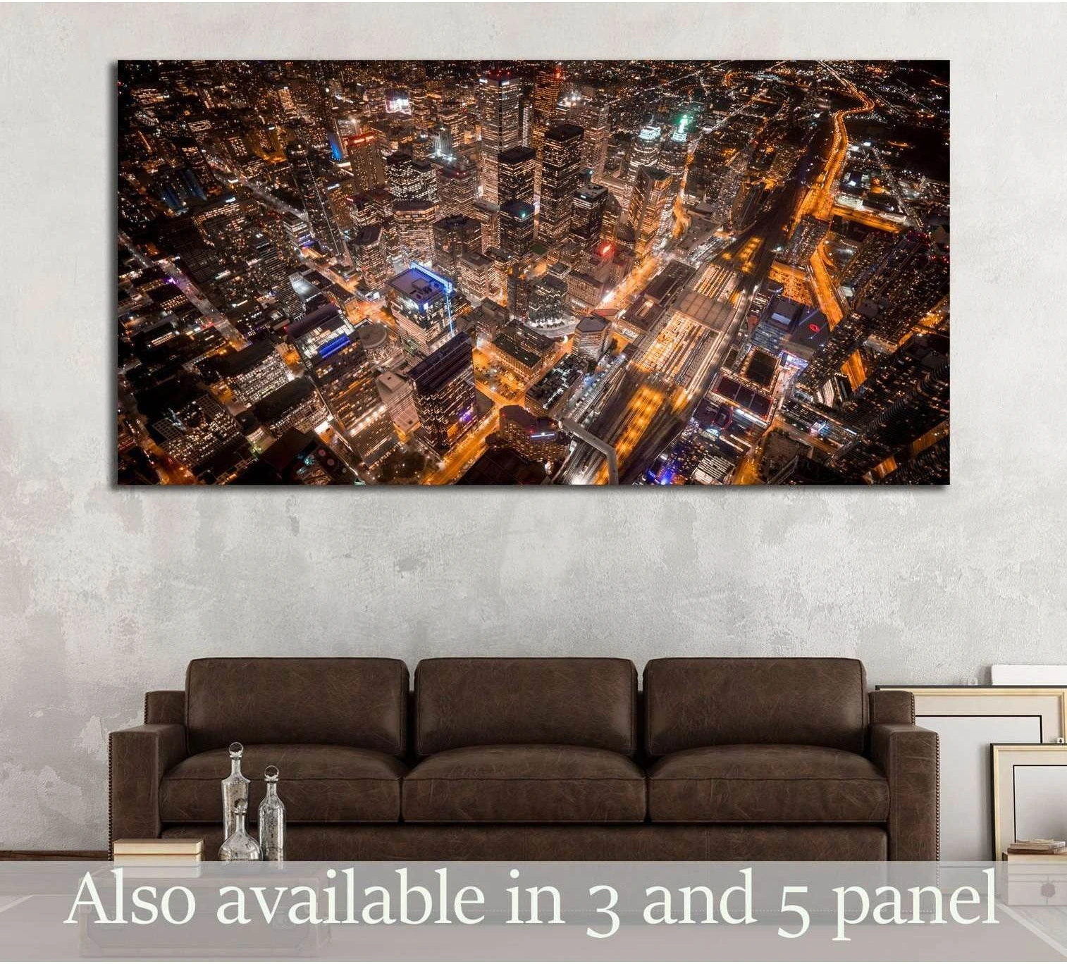 Aerial Toronto skyline canvas print at night displayed above a brown sofa in a modern living room