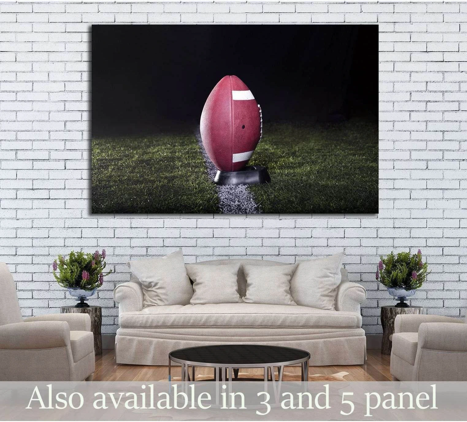 American football canvas print with ball on kicking tee under lights, displayed above sofa in neutral living room