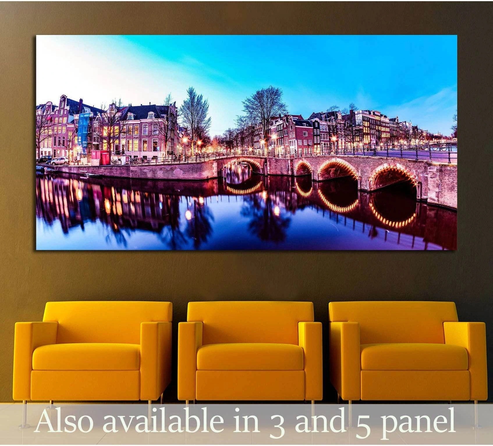 Amsterdam canal canvas print with glowing bridge arches and Dutch houses above chairs in a modern room