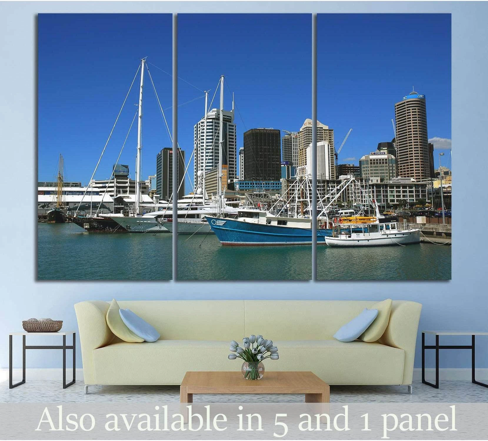 Auckland harbor skyline canvas print with sailboats, shown above a sofa in a modern living room