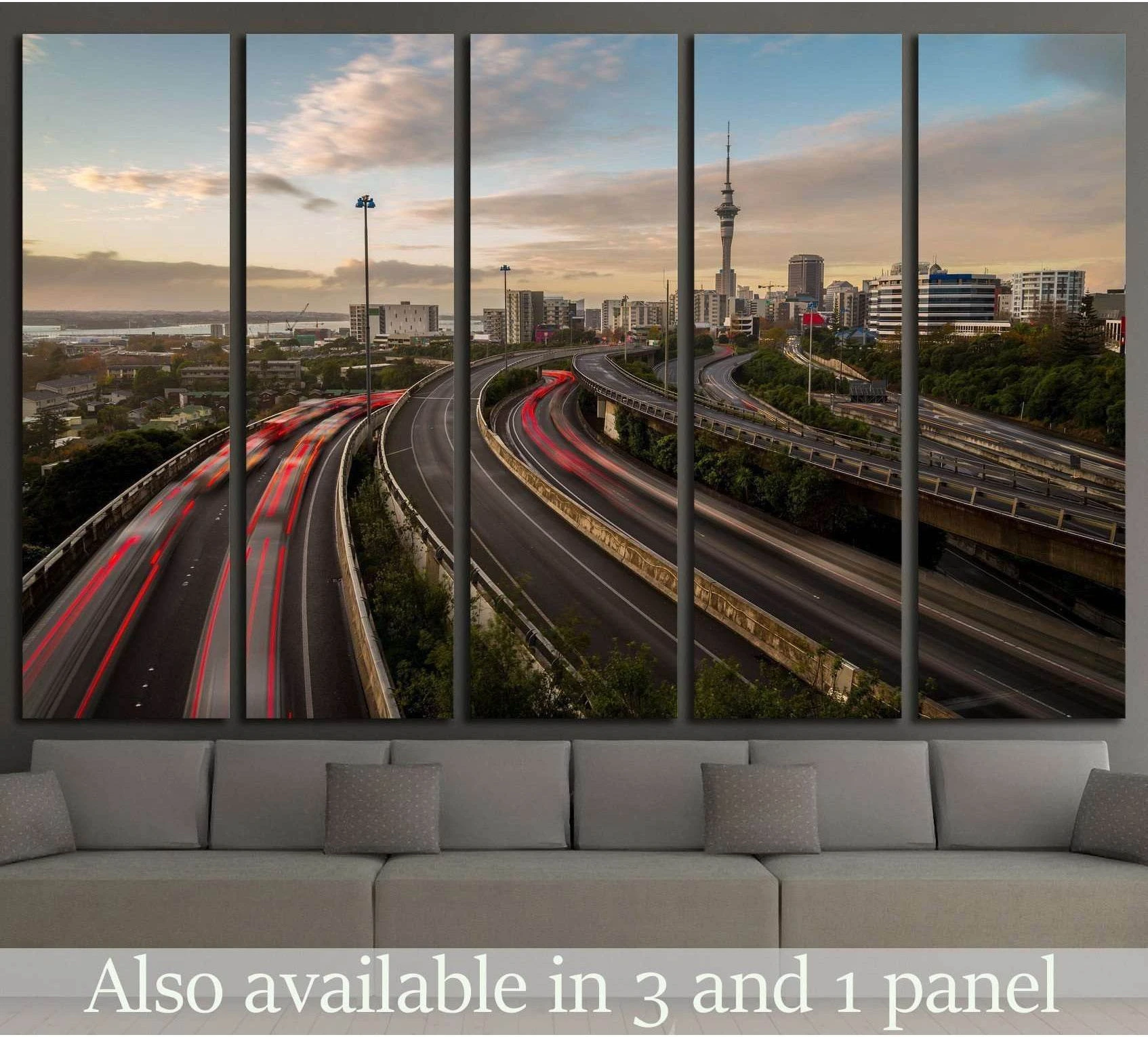 Auckland Sky Tower canvas print with motorway light trails at dusk above a sofa in a modern living room