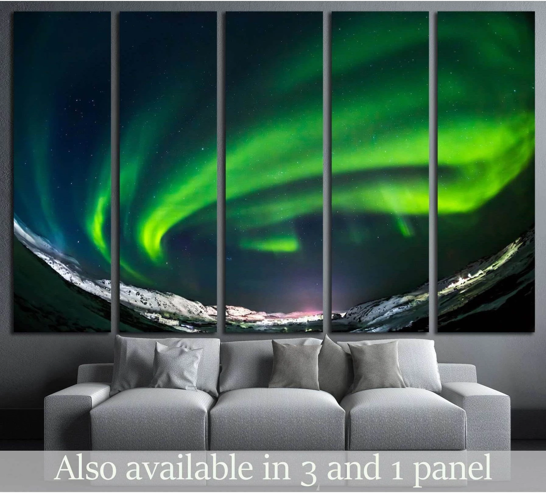 Green northern lights canvas print over snowy Arctic mountains above a sofa in a modern living room