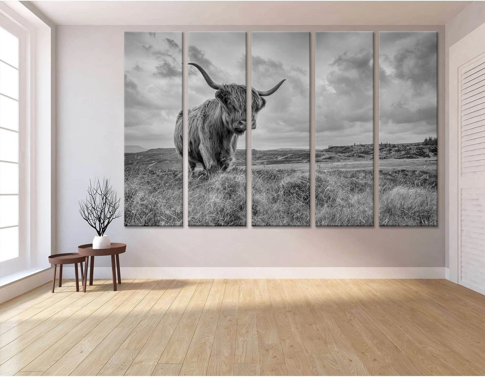 A black and white photograph of a Highland cow in a field of tall grass, with a dramatic sky and mountains in the background., product view 3