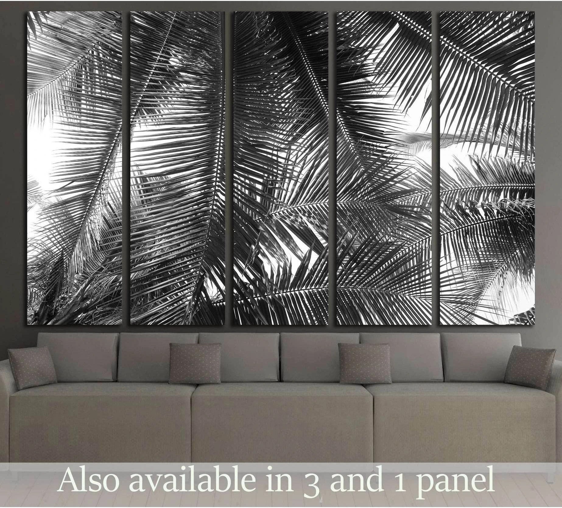 Black and white palm leaf canvas print hung above a sofa in a modern neutral living room