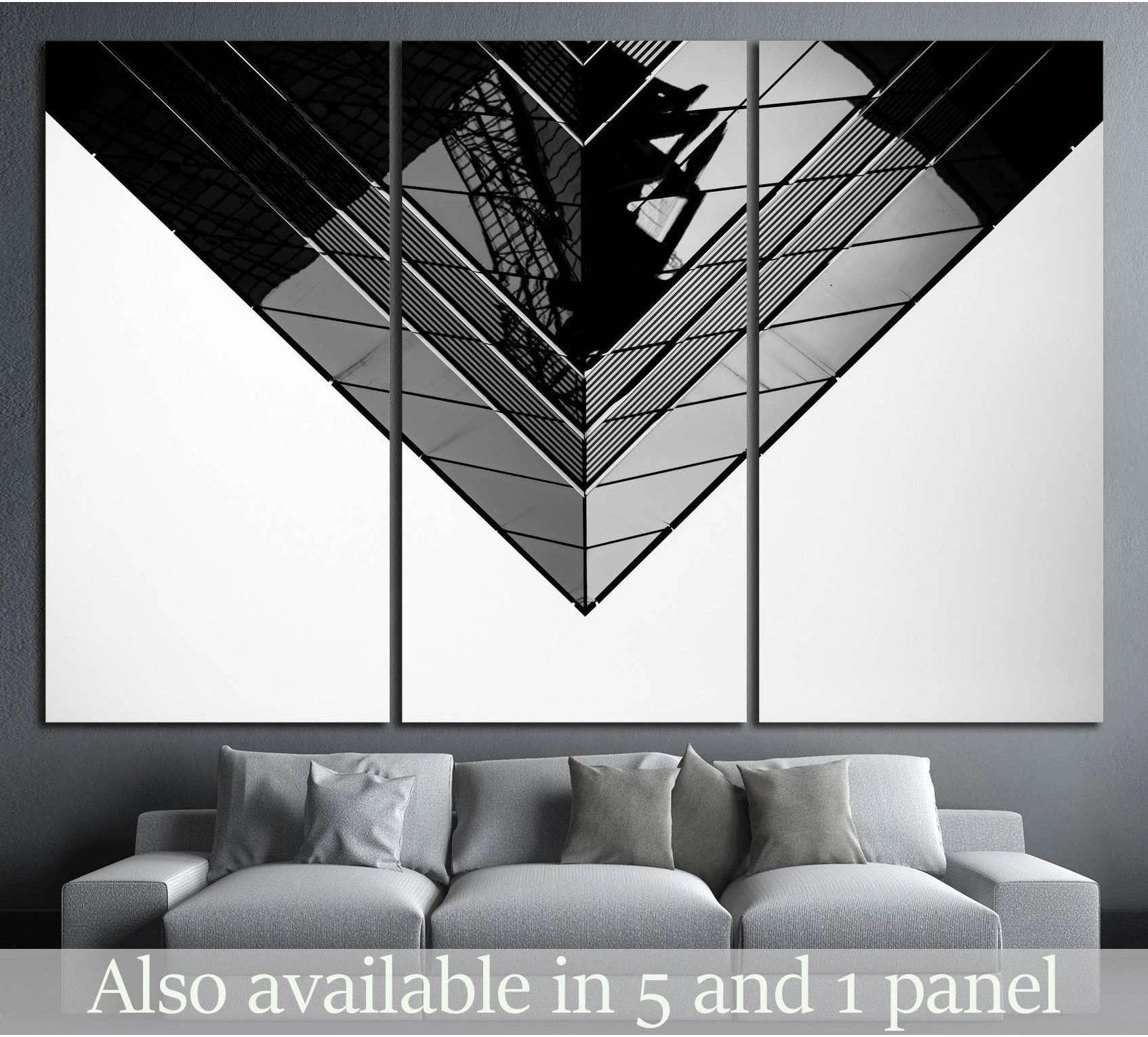 Black and white geometric skyscraper canvas print displayed above sofa in a modern living room