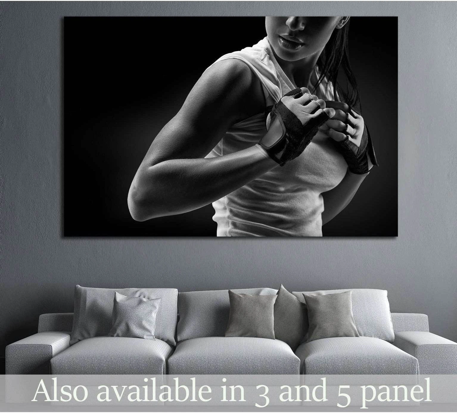 Black and white fitness woman boxing canvas print hung above a sofa in a modern living room