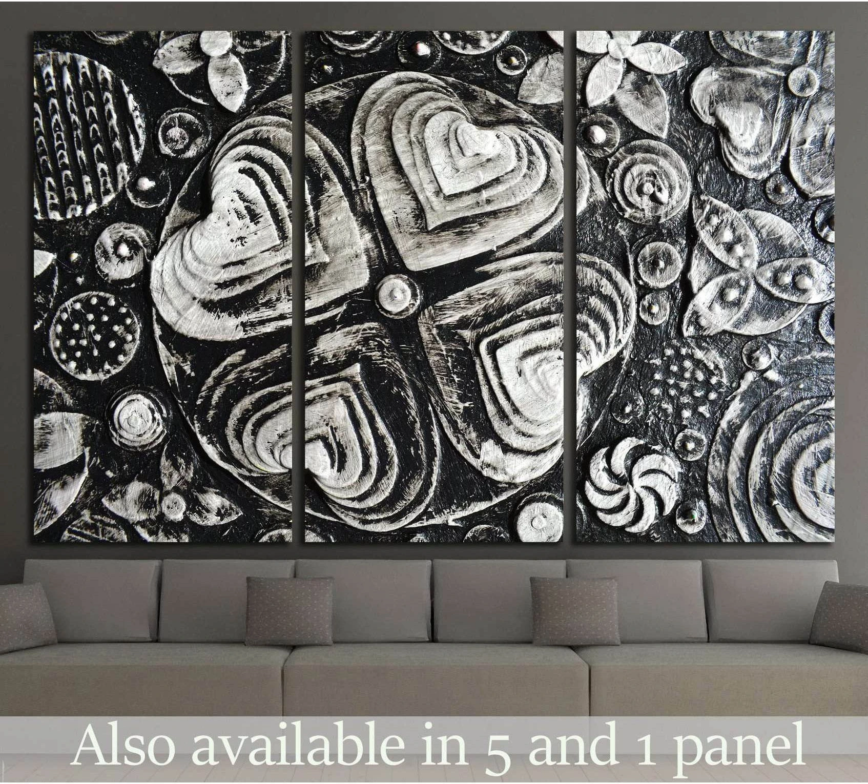 Black and white grunge floral triptych canvas print above a sofa in a modern living room
