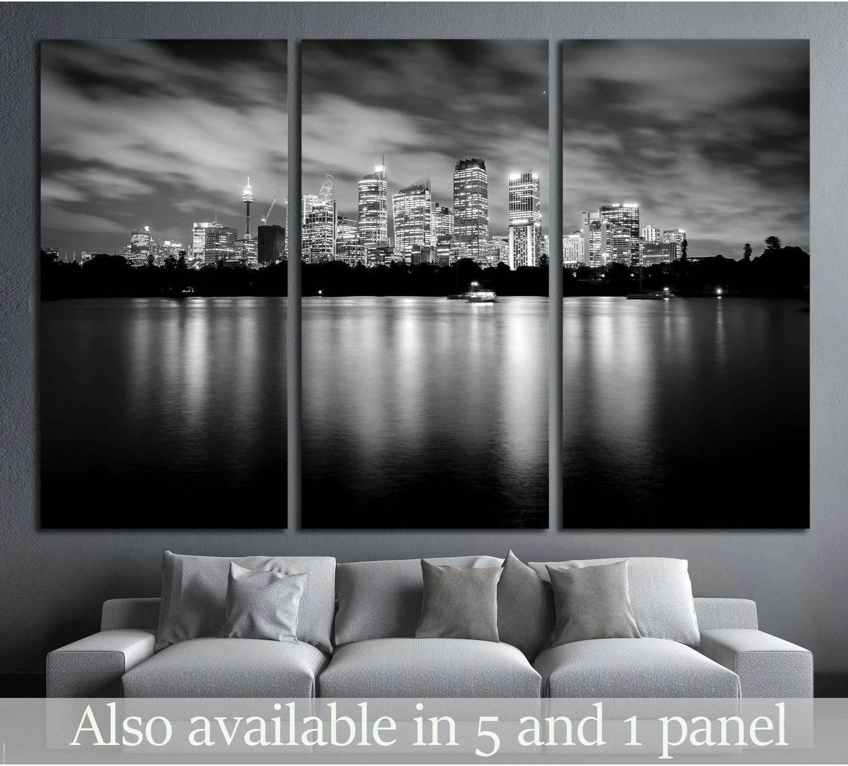 Black and white Sydney skyline triptych canvas print above a sofa with night reflections on the water