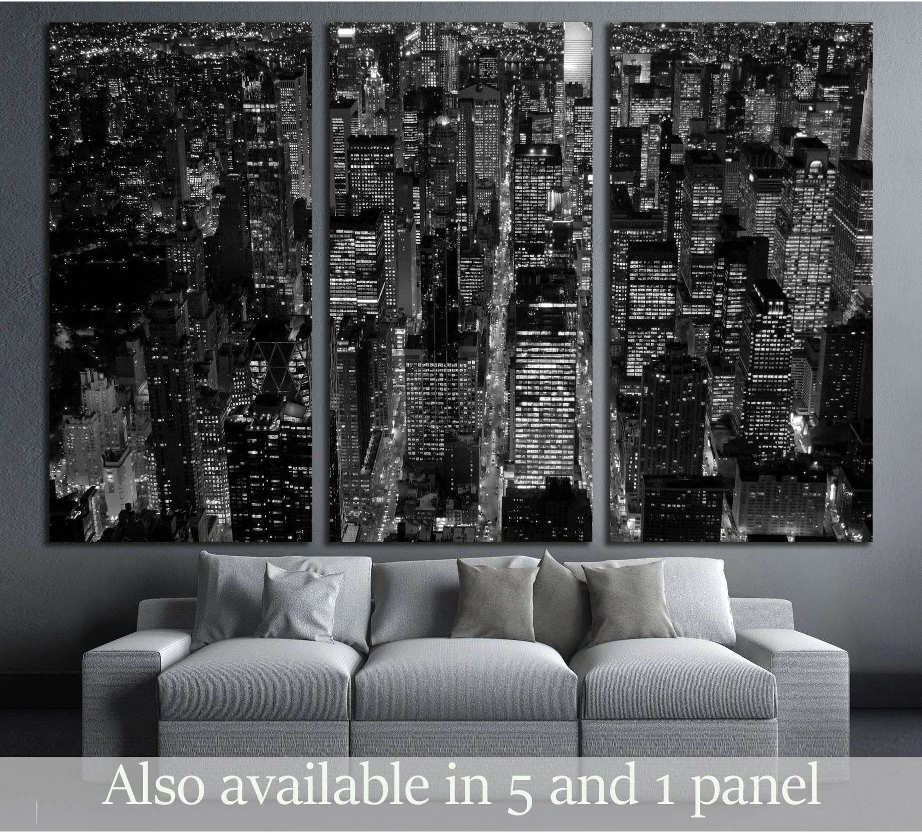 Black and white NYC skyline triptych canvas print above a sofa in a modern gray living room