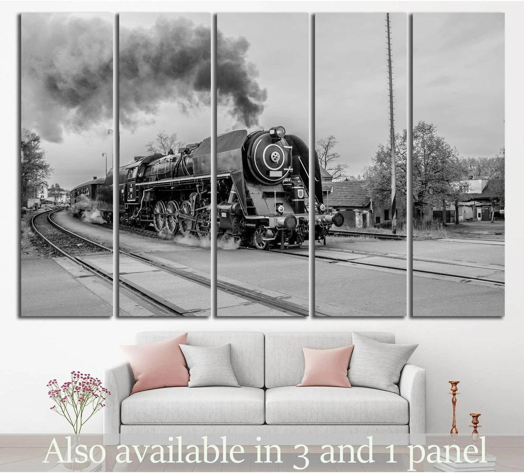 Black and white steam train canvas print in five-panel layout above a sofa in a modern living room