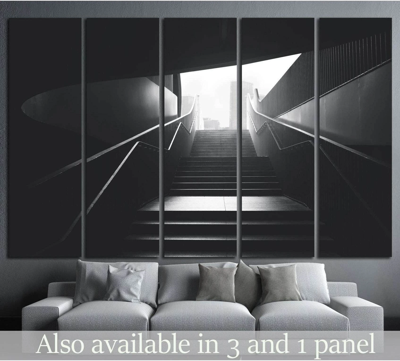 Black and white urban stairs canvas print hung above a sofa in a modern living room