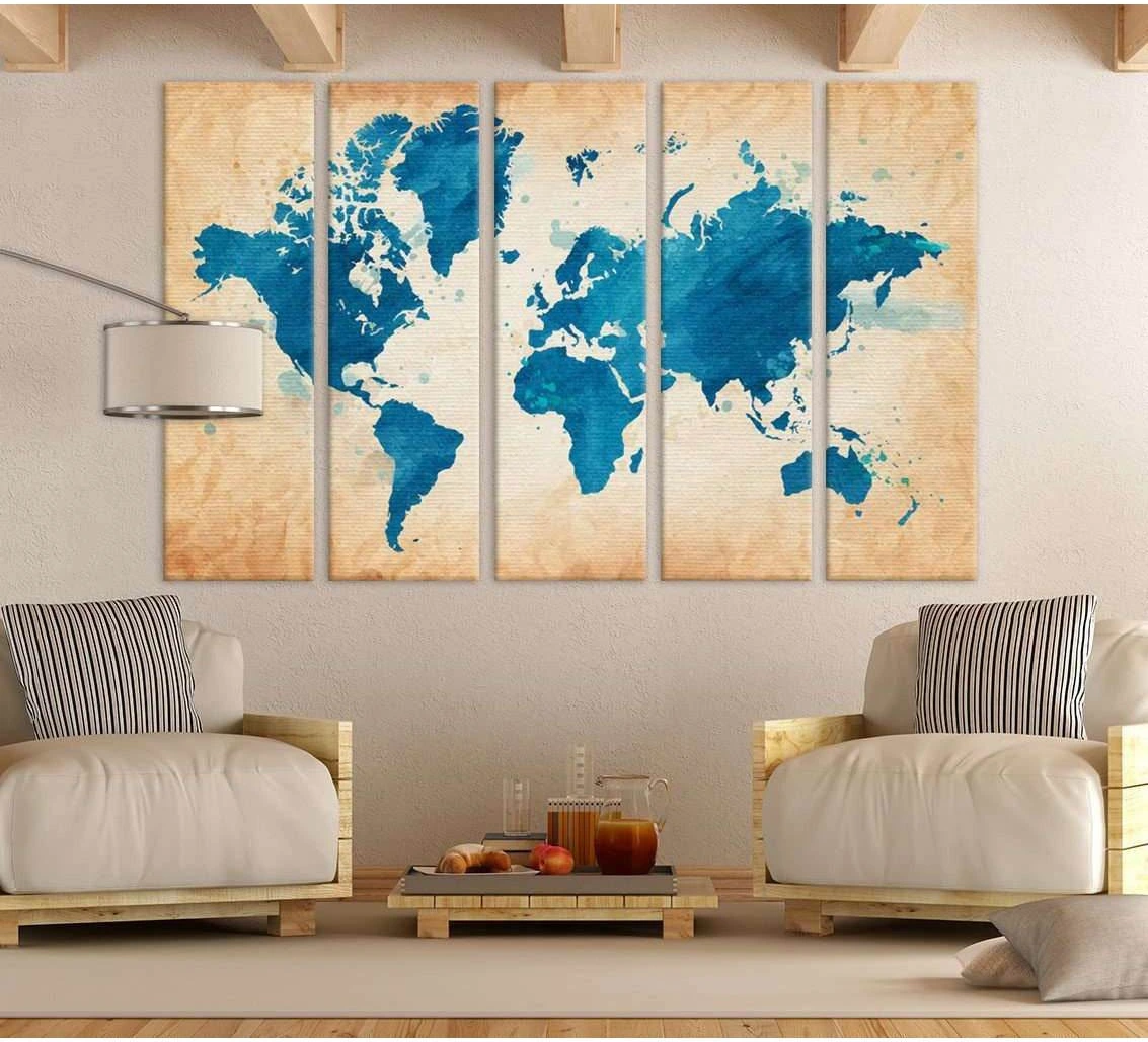 Blue world map canvas print in five-panel layout above chairs in a warm neutral living room