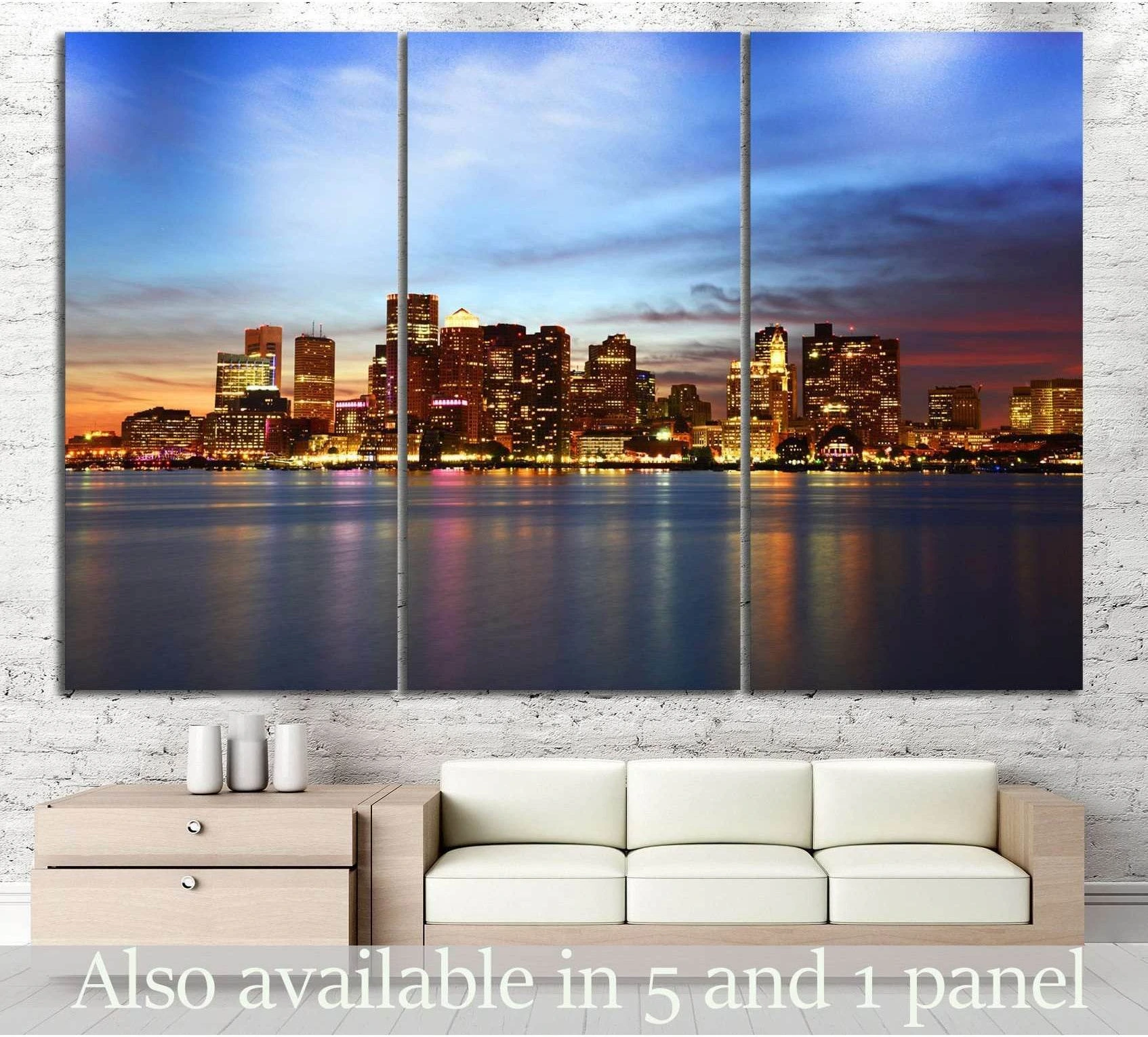Boston skyline triptych canvas print with glowing harbor lights at blue hour above a sofa in a modern living room