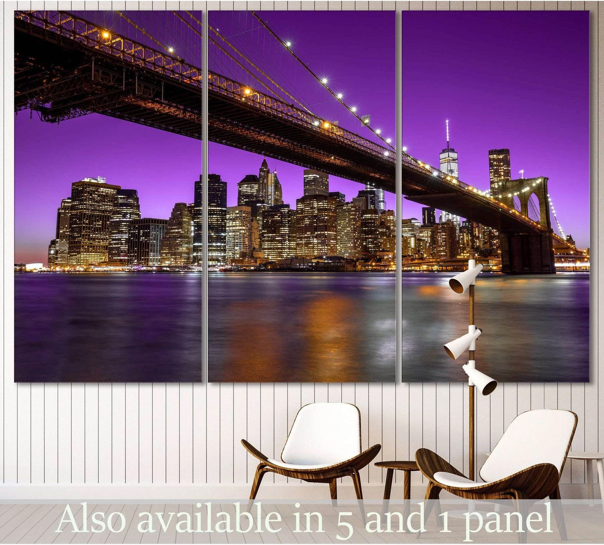 Brooklyn Bridge triptych canvas print with purple NYC skyline at night above modern chairs