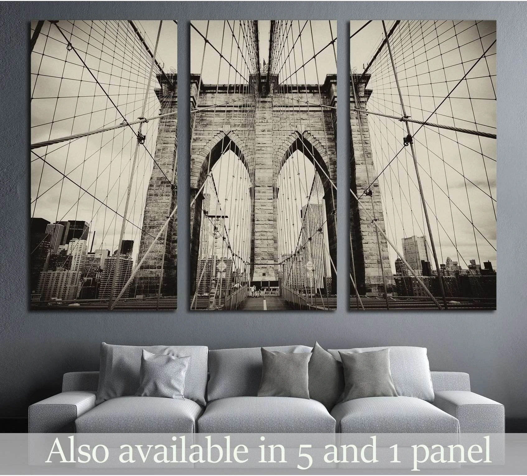 Sepia Brooklyn Bridge triptych canvas print above a gray sofa in a modern living room