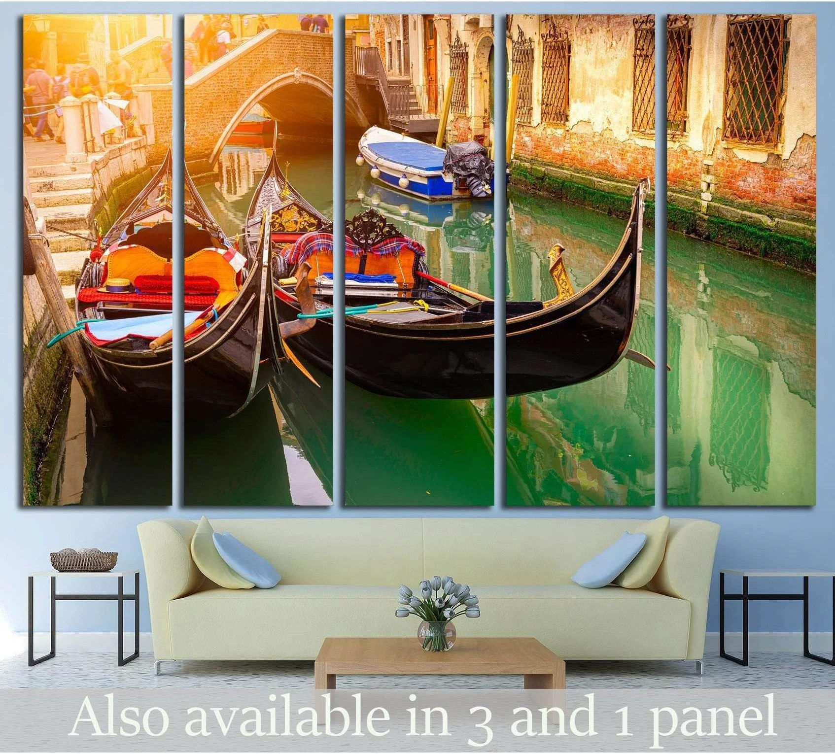 Venice gondola canvas print with two gondolas in green canal water beneath a brick bridge, hung above a sofa