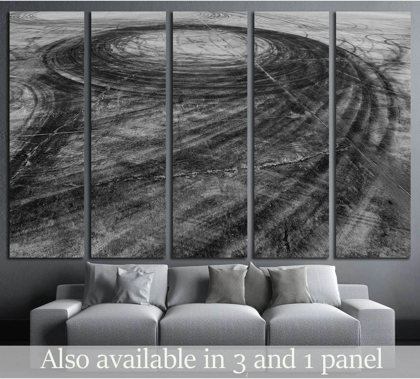 Black and white drift skid marks canvas print above sofa in a modern industrial room