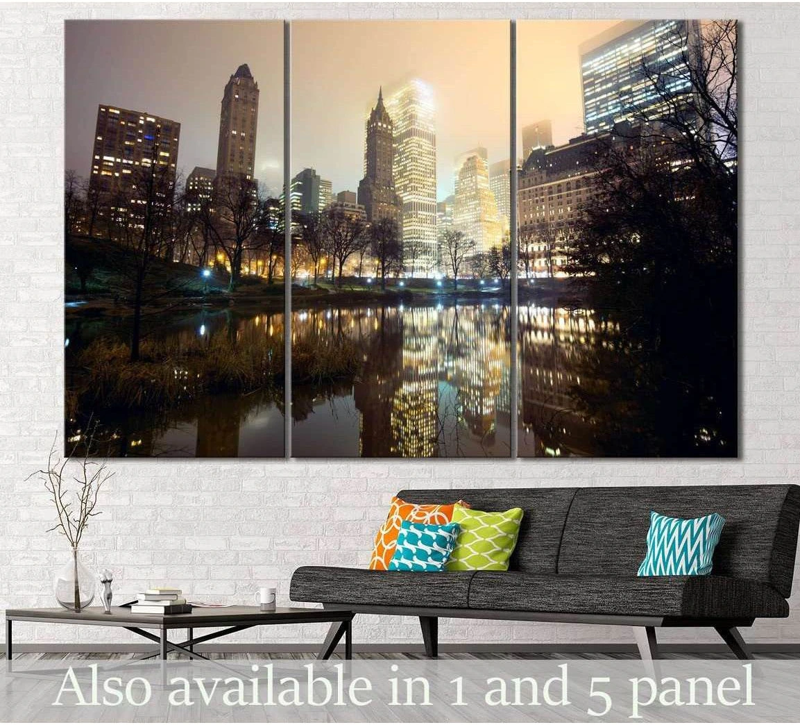 Central Park New York triptych canvas print with glowing skyline reflections above a sofa in a modern living room