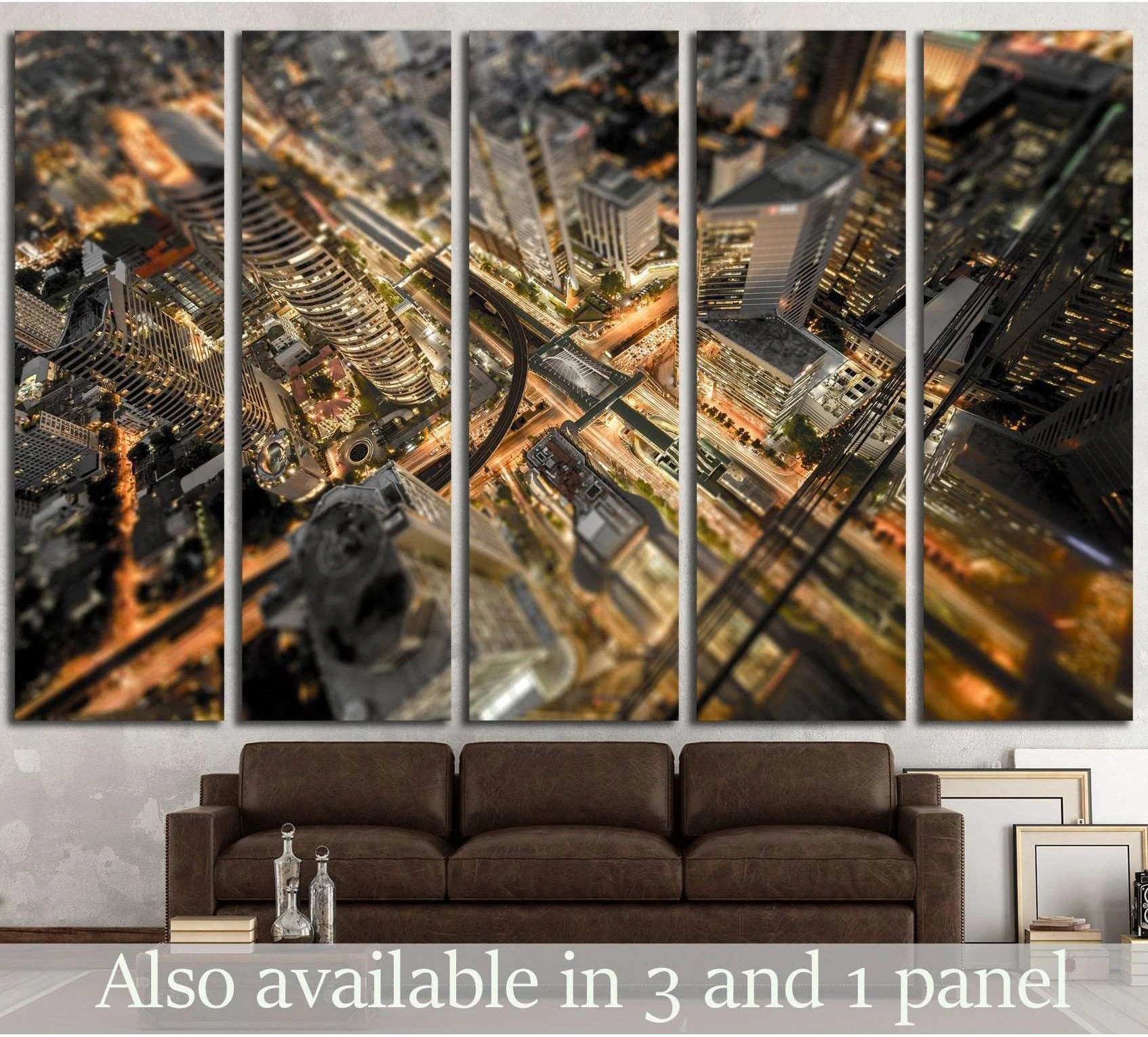 Aerial night cityscape canvas print with glowing roads and skyscrapers above a sofa in a modern living room