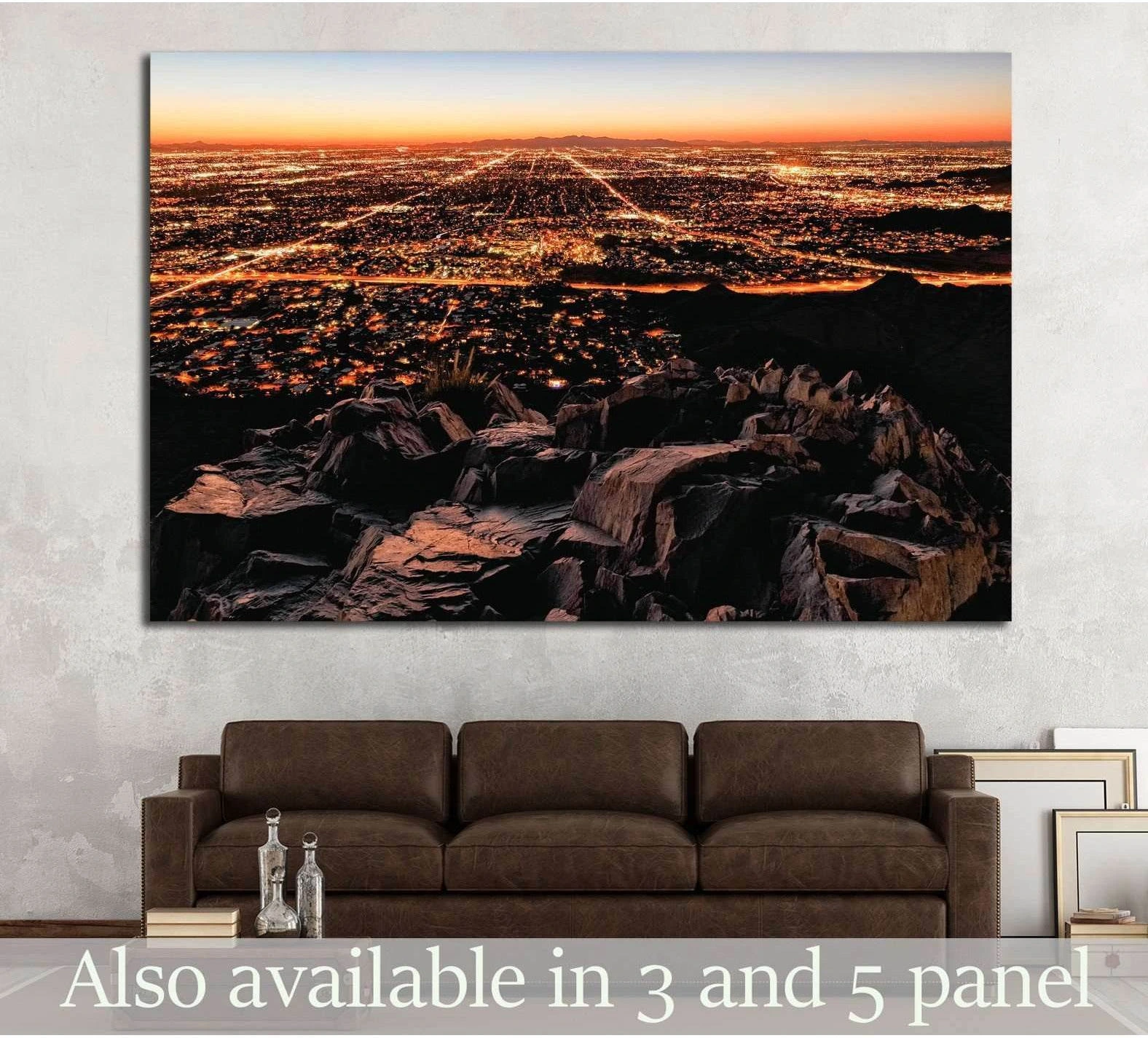 City lights mountain view canvas print above sofa with glowing skyline and rocky foreground