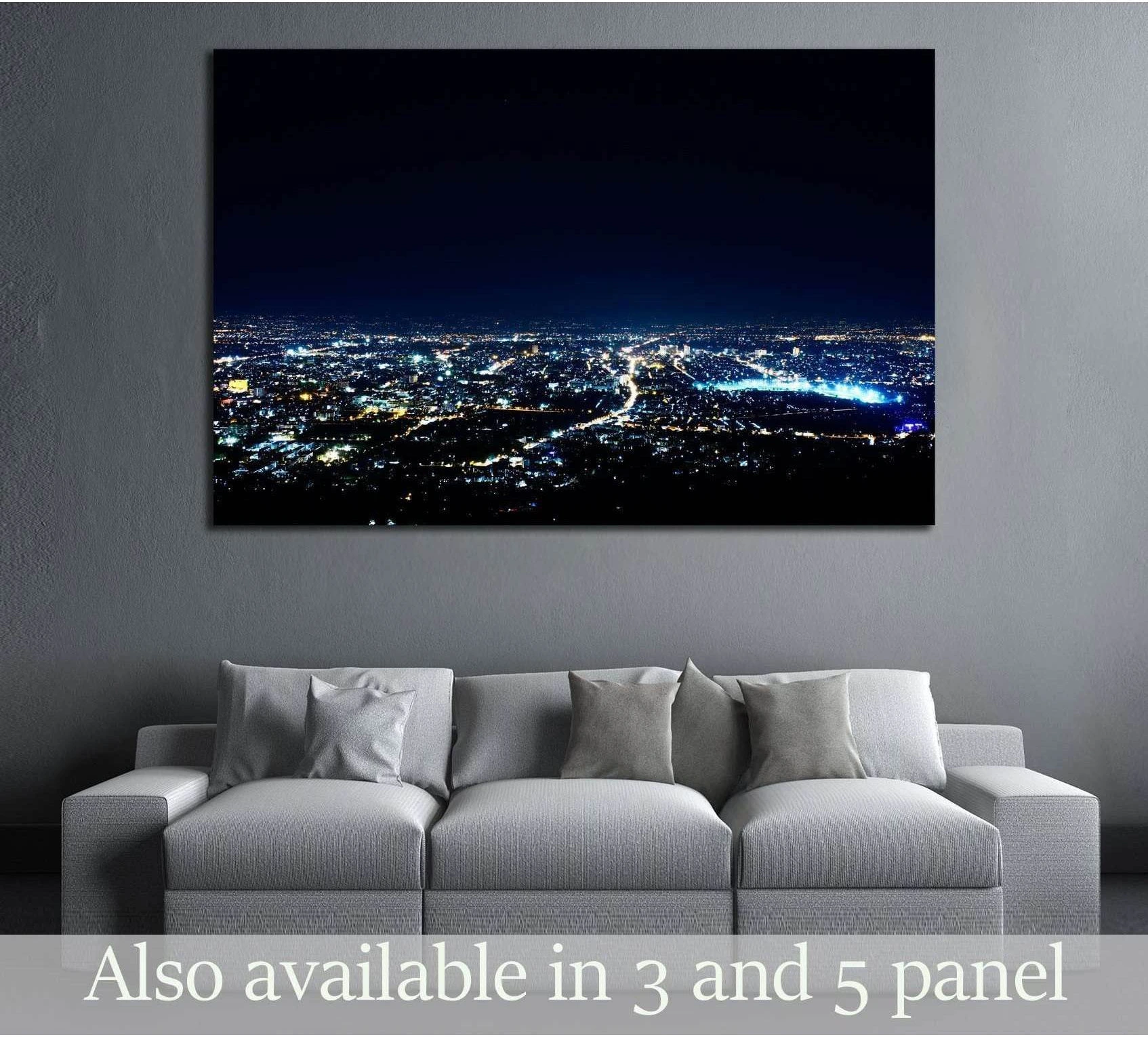 Panoramic city night skyline canvas print with blue lights above a sofa in a modern living room