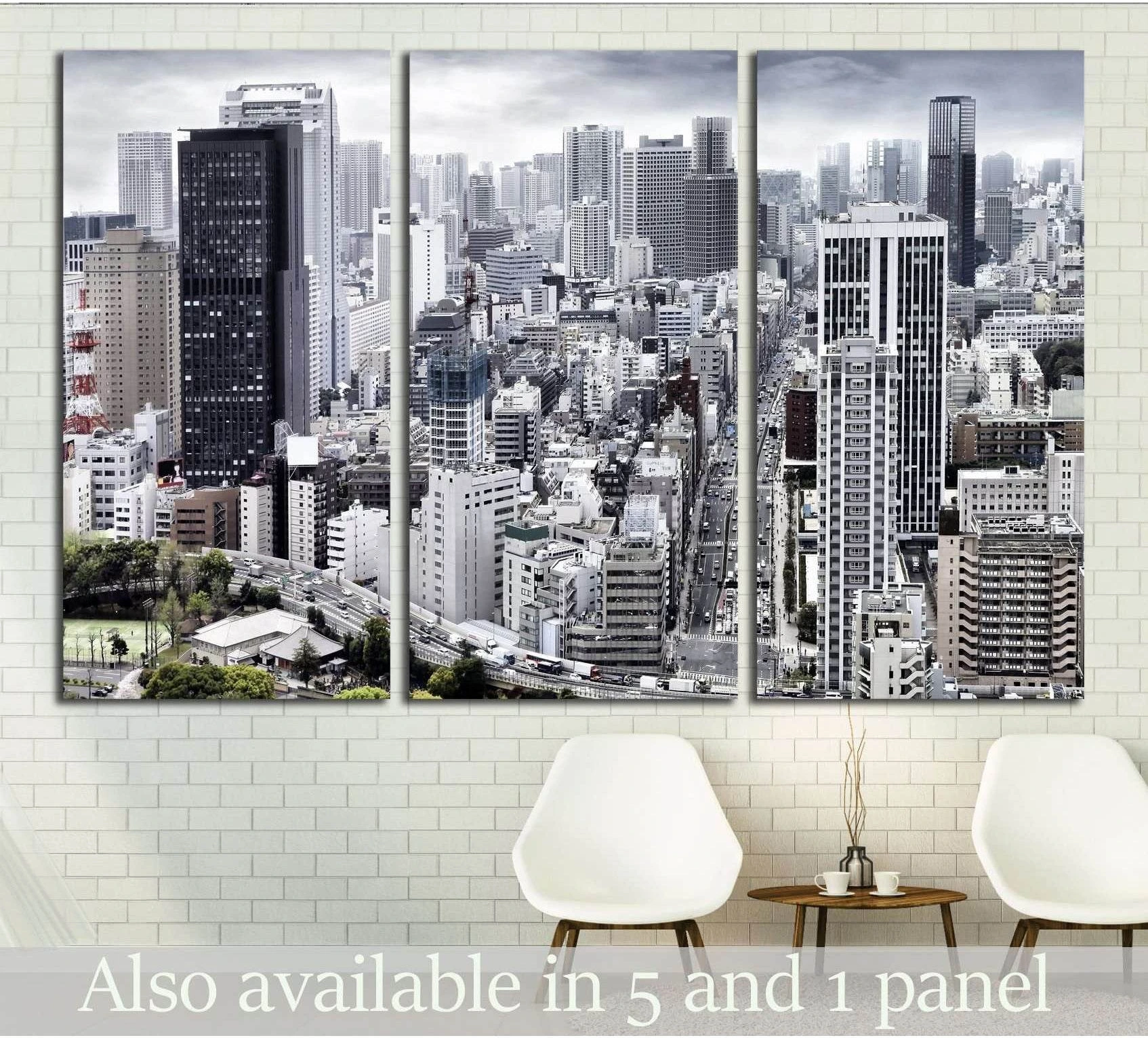 Monochrome city skyline triptych canvas print with dense skyscrapers above chairs in a modern room