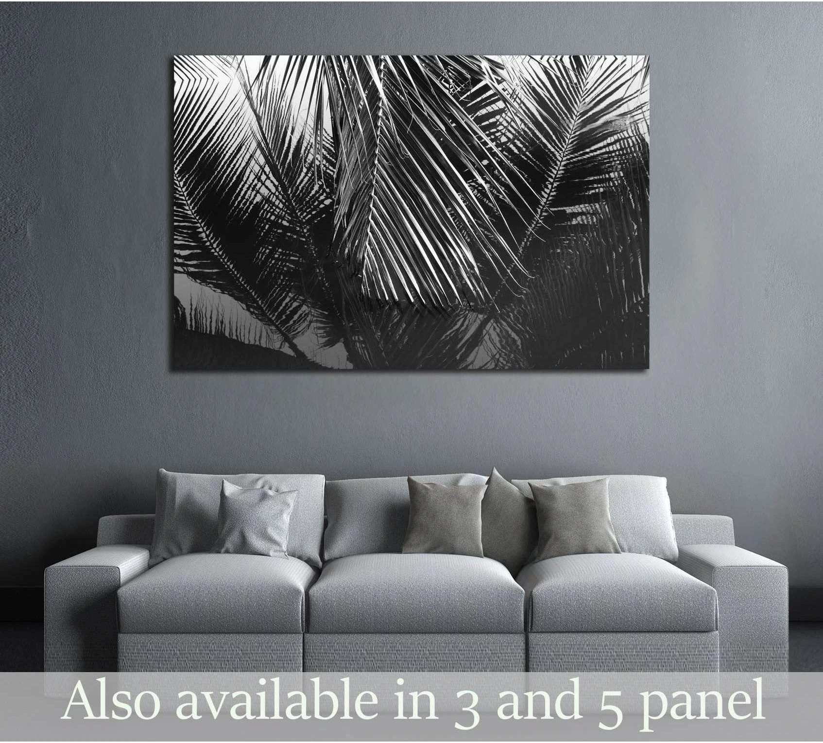 Black and white coconut leaves canvas print hung above a gray sofa in a modern living room