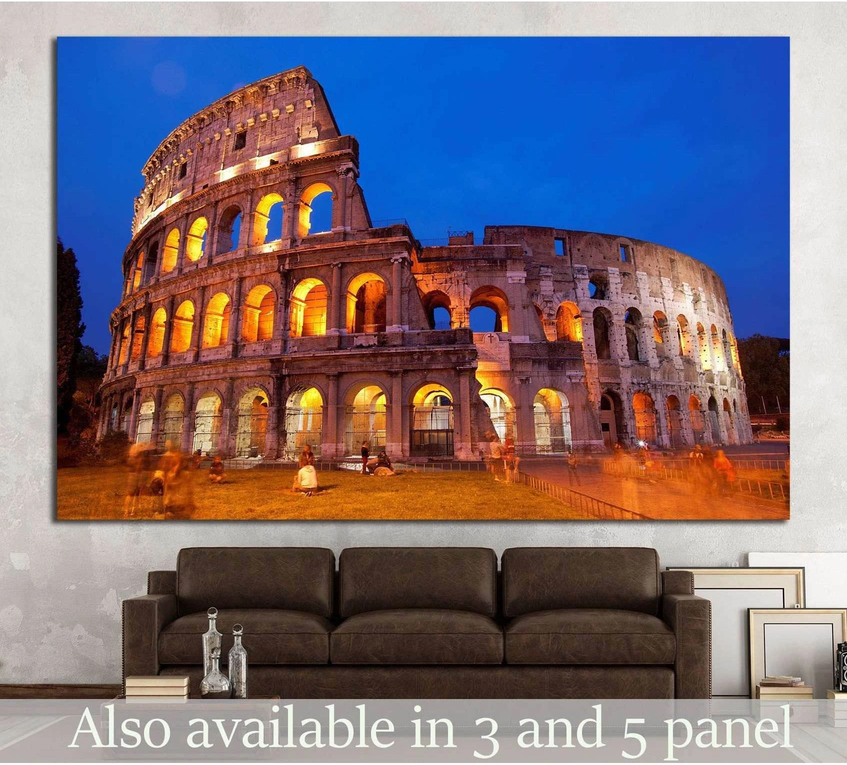 Colosseum Rome canvas print with glowing arches at blue hour above a sofa in a modern living room
