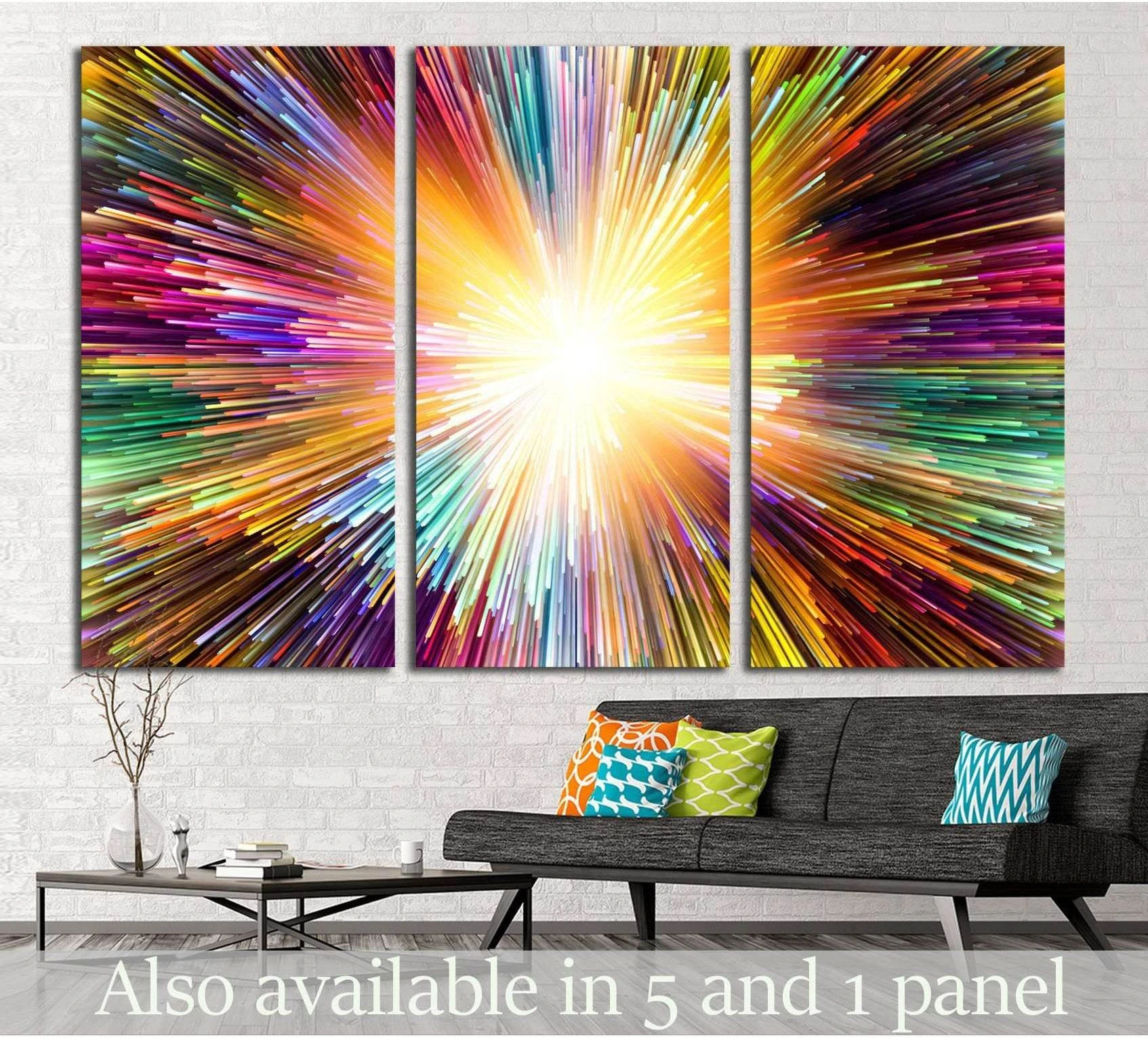 Abstract triptych canvas print with a bright white starburst center and multicolor radial streaks above a sofa