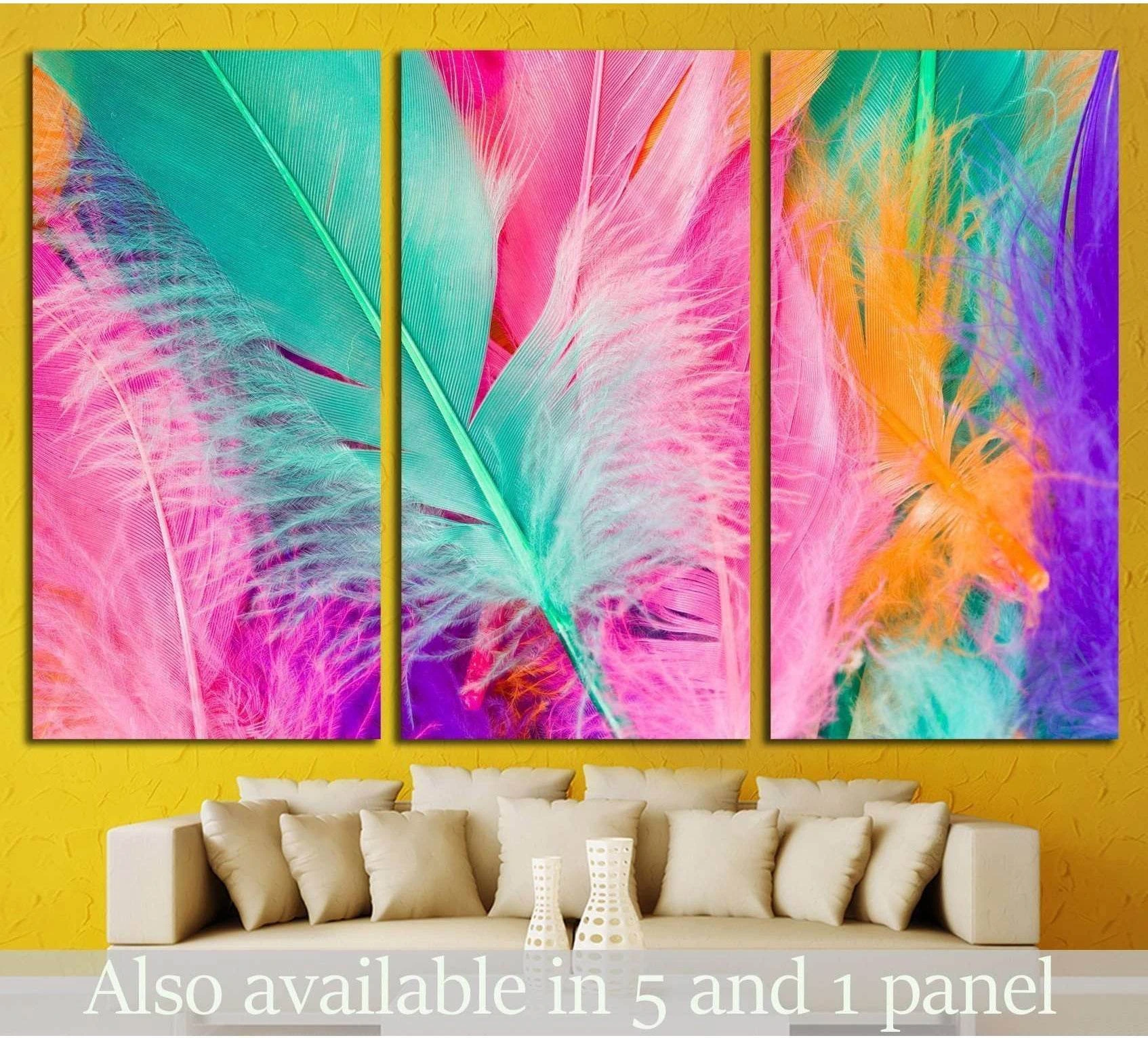 Triptych colorful feather canvas print in pink, turquoise, orange, and purple above beige sofa