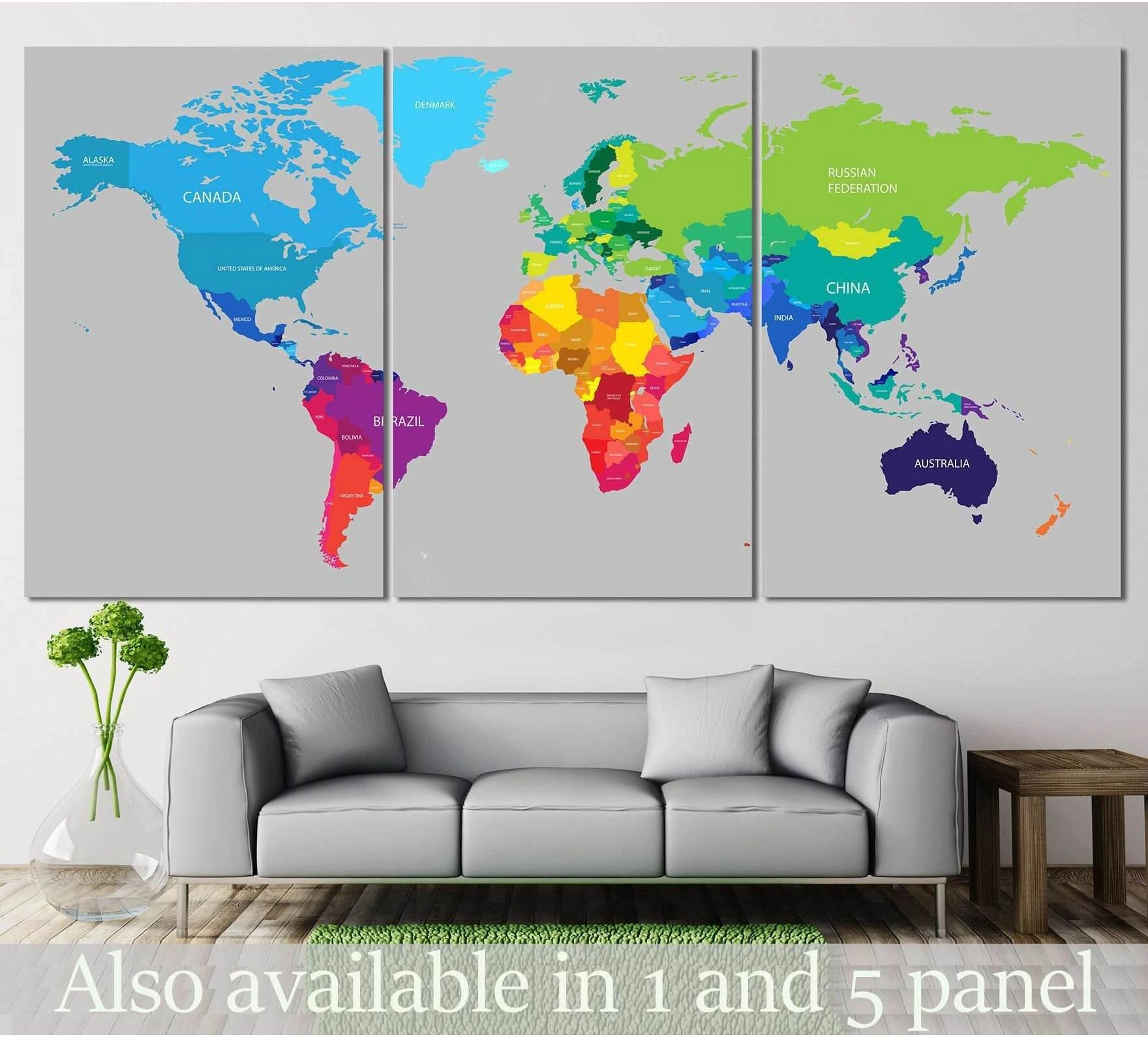 Colorful world map triptych canvas print above a gray sofa in a modern living room