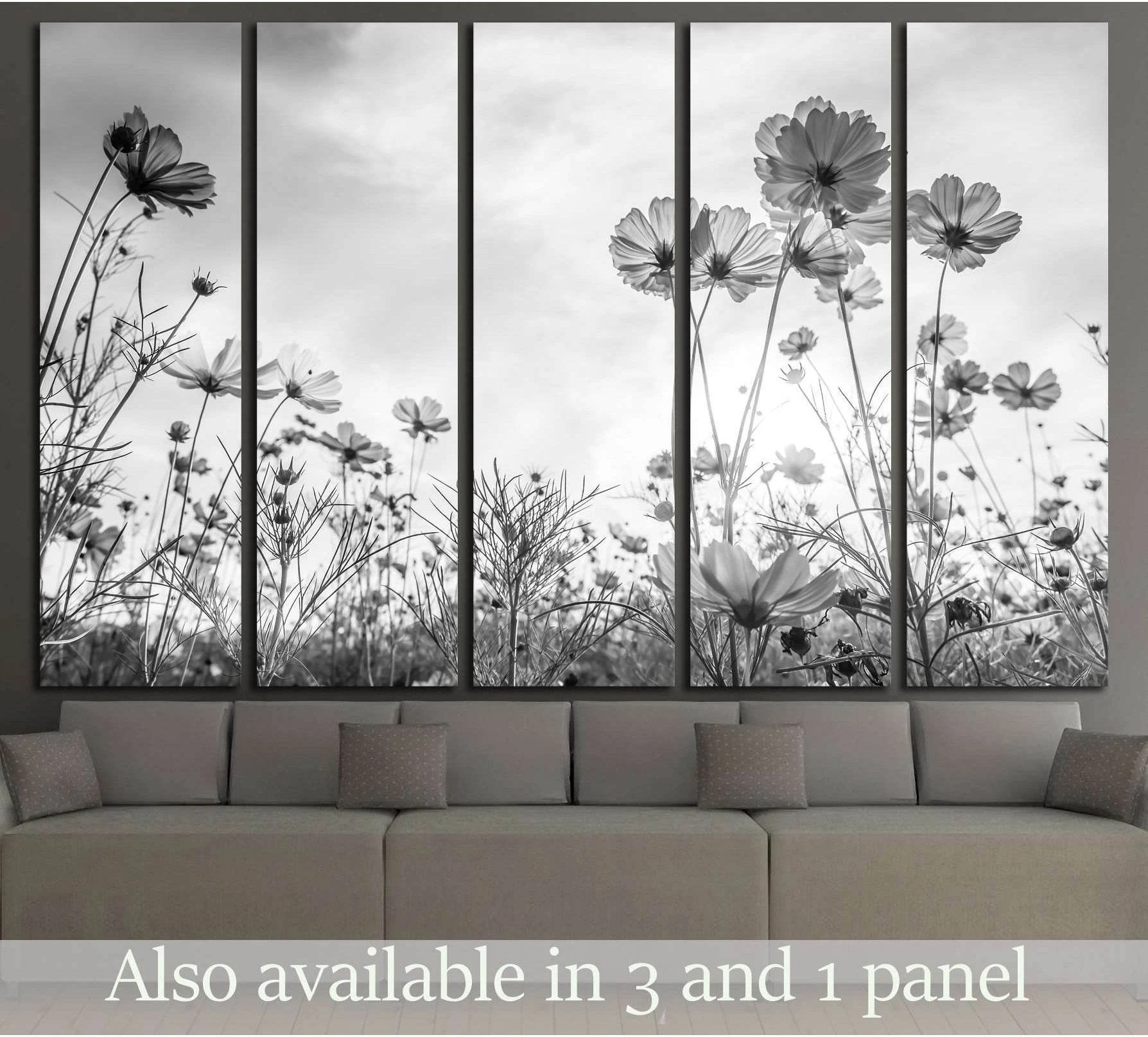 Black and white cosmos flower canvas print in a multi-panel layout above a sofa in a neutral living room