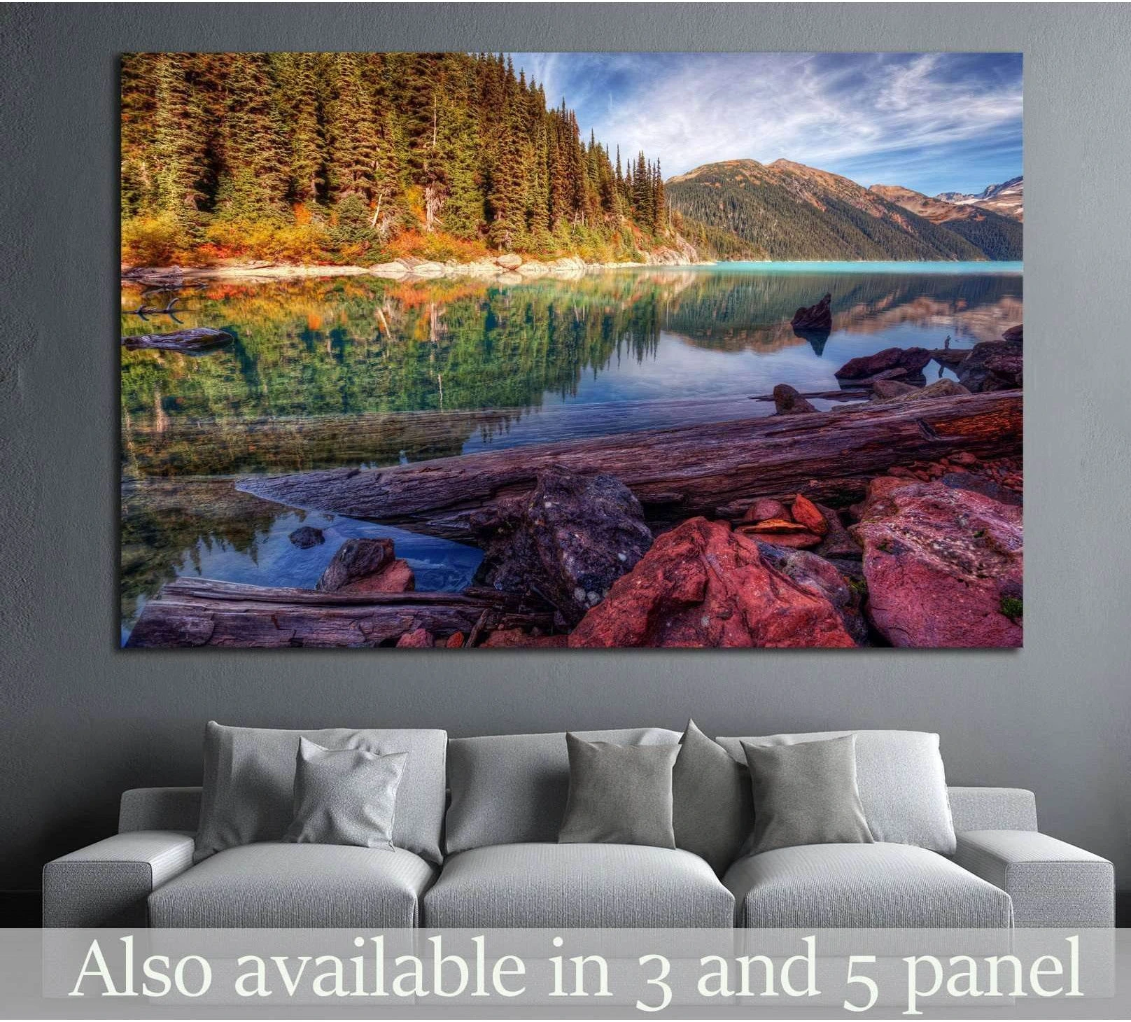 Mountain lake canvas print with turquoise water, pine forest, and red rock shore above a sofa