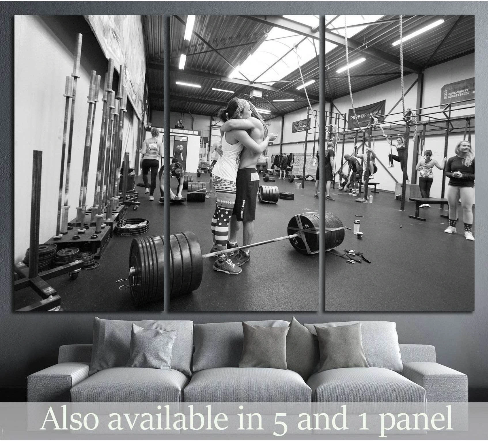 Black and white CrossFit canvas print featuring athletes hugging in a gym, displayed above a sofa