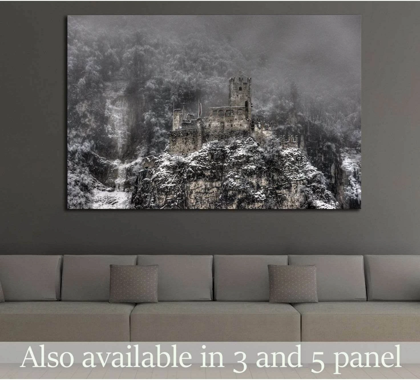 Snow-covered castle ruins canvas print above a sofa in a moody modern living room